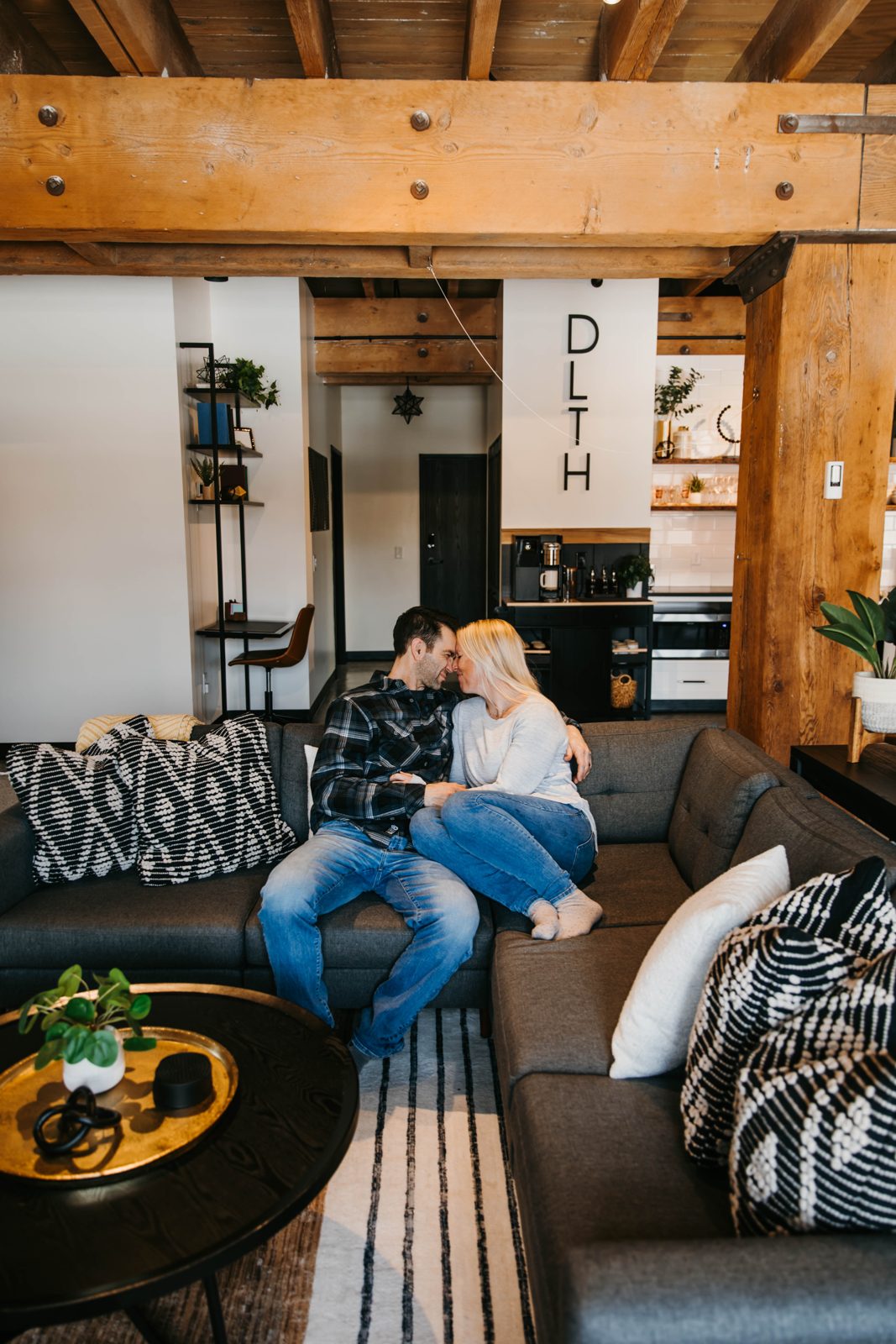 A couple relaxing on the sofa in a Brix condo with Douglas Fir beams in Canal Park
