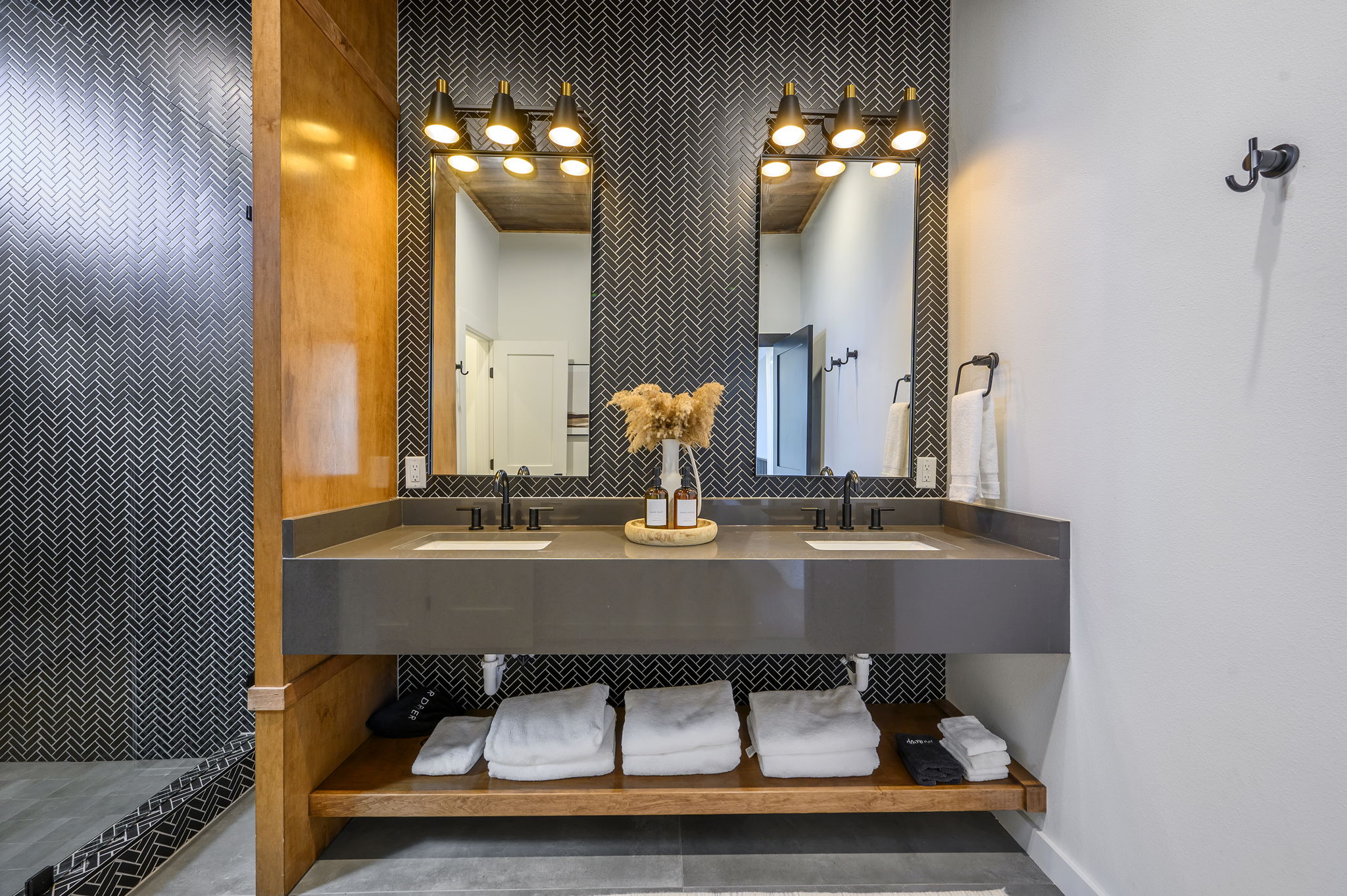 Semi-private bathroom for those staying in the Bunk room. This bathroom features modern teak finishes, stunning modern design, and an oversized rain shower with dual shower heads. 