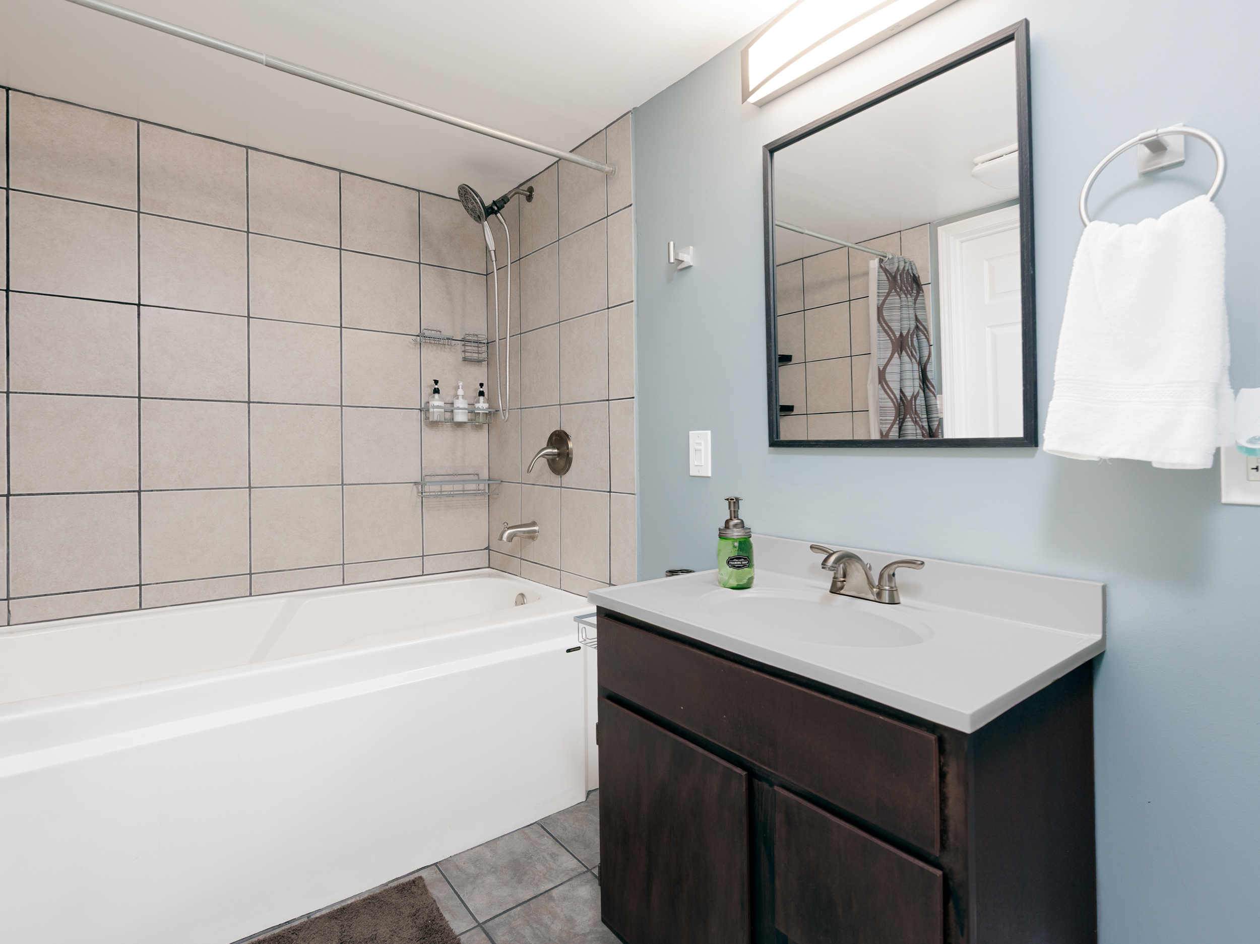 Basement bathroom vanity and sink area with practical storage and lighting. Designed to accommodate the lower-level office & living suite.
