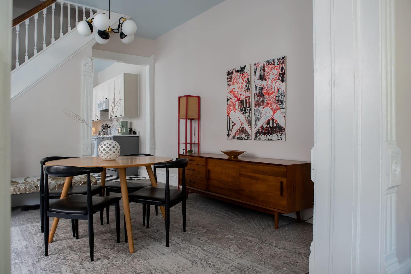 An inviting dining space layered with local art, historic character, and modern ease - a bluetooth speaker and games tucked in console for evenings in. 