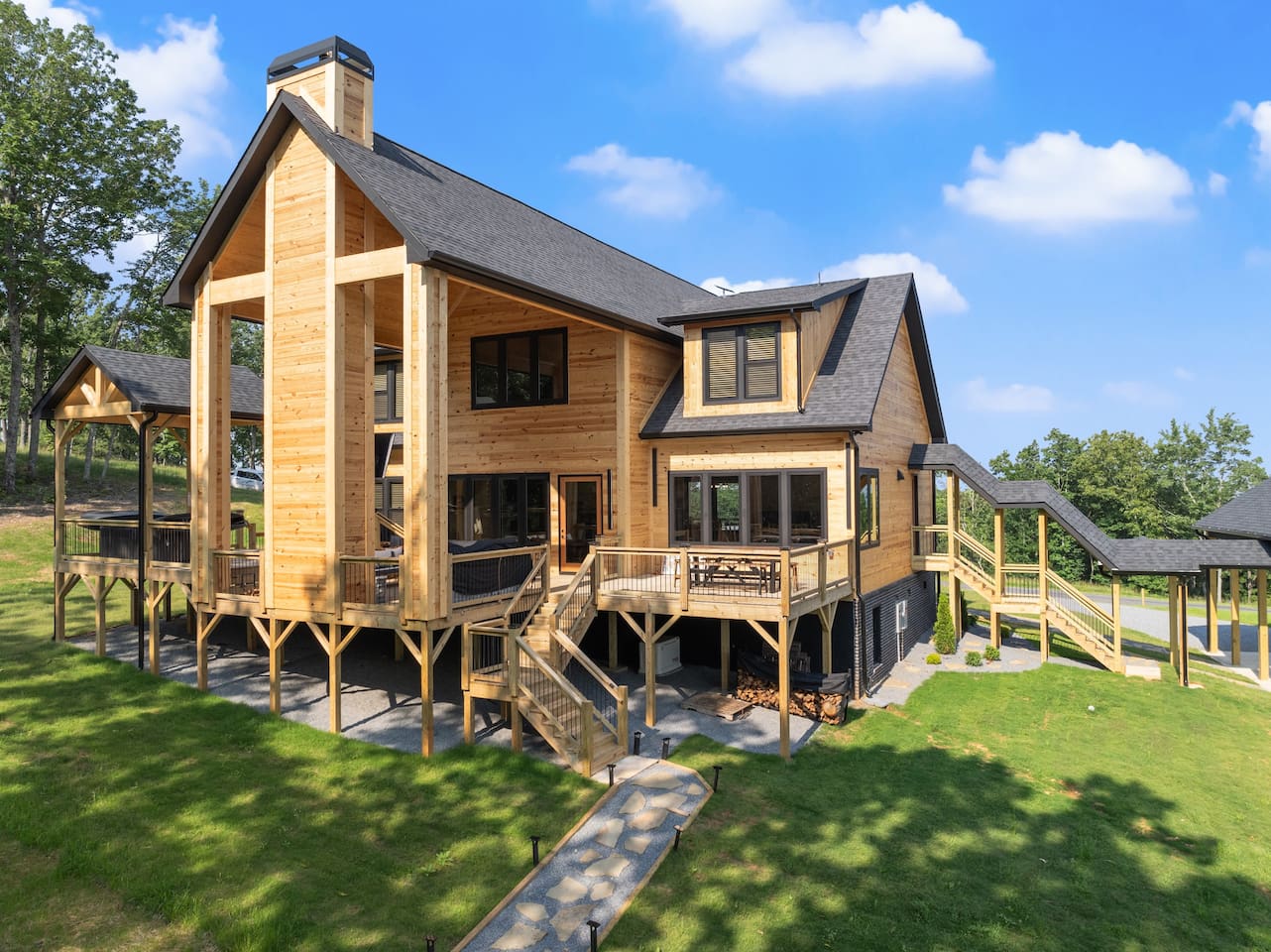 This rear view highlights the cabin’s stunning architecture, multiple decks, and cozy outdoor nooks.