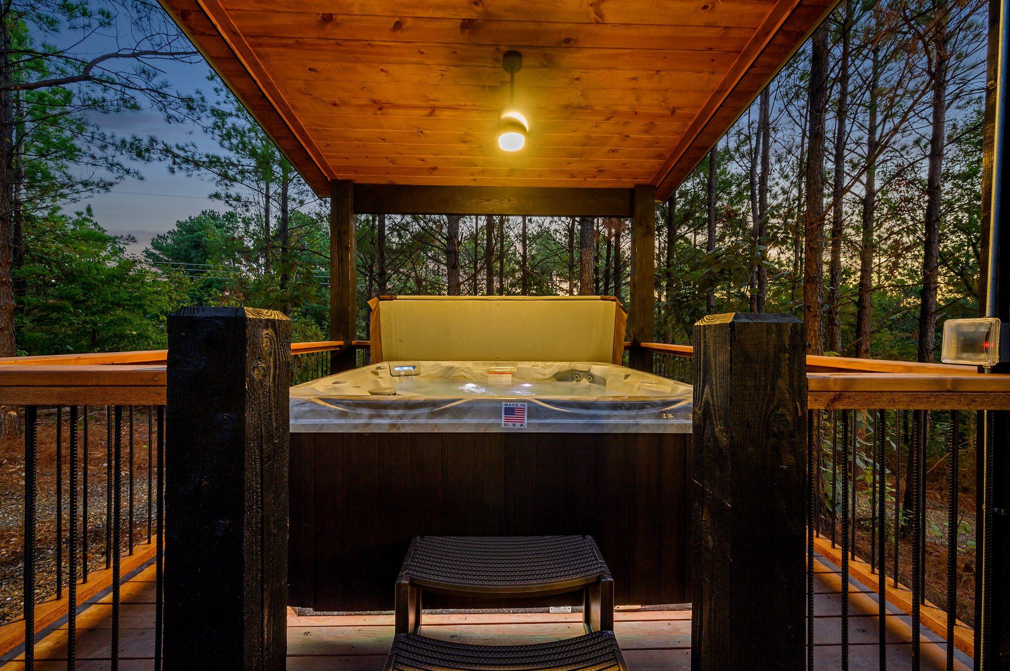 Sunset soak: Private hot tub with breathtaking forest views.