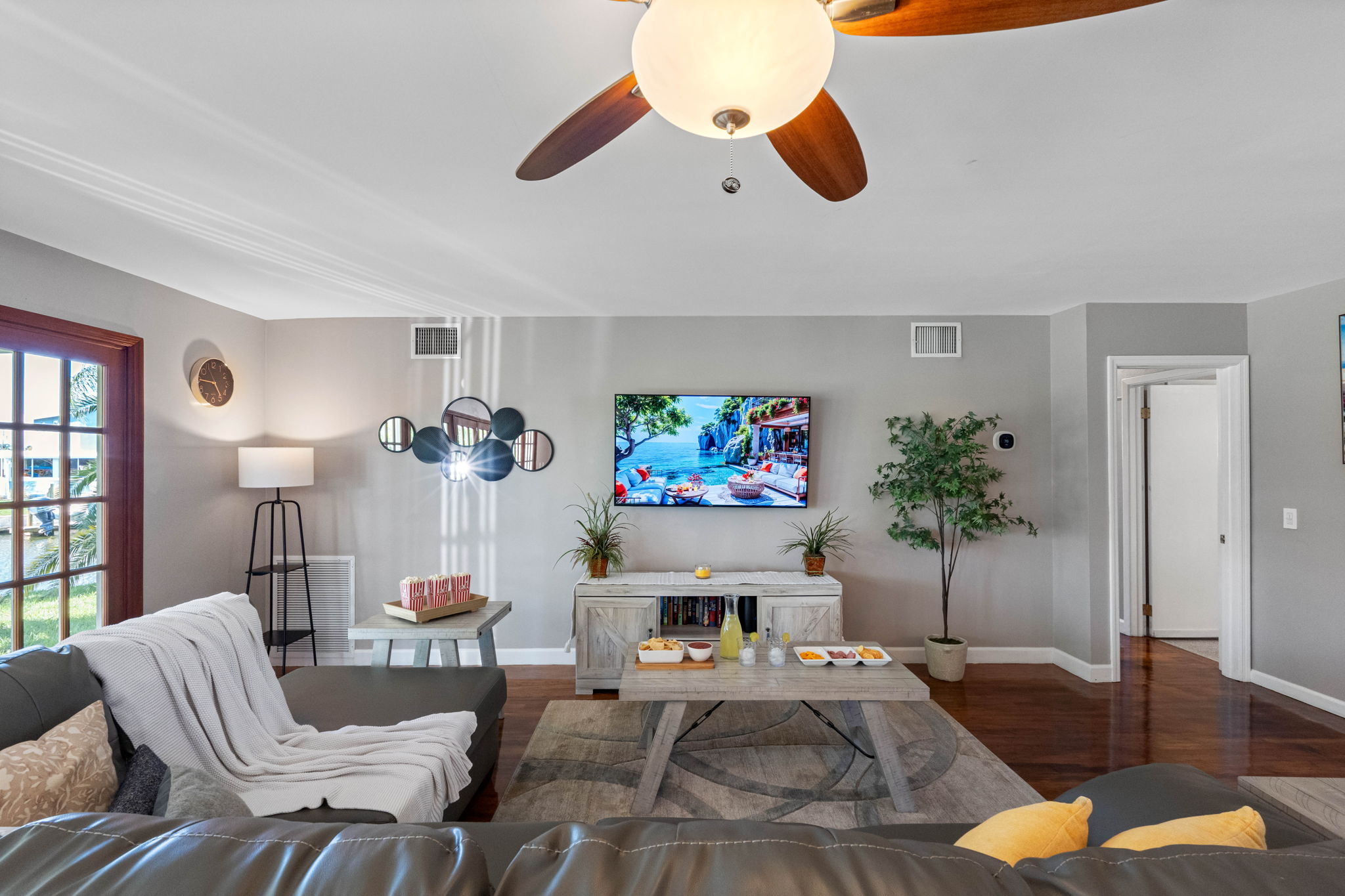 Outfitted with a large mounted TV, spacious sectional seating, and snack-ready tables, this living room is perfect for family movie nights or casual entertaining.
