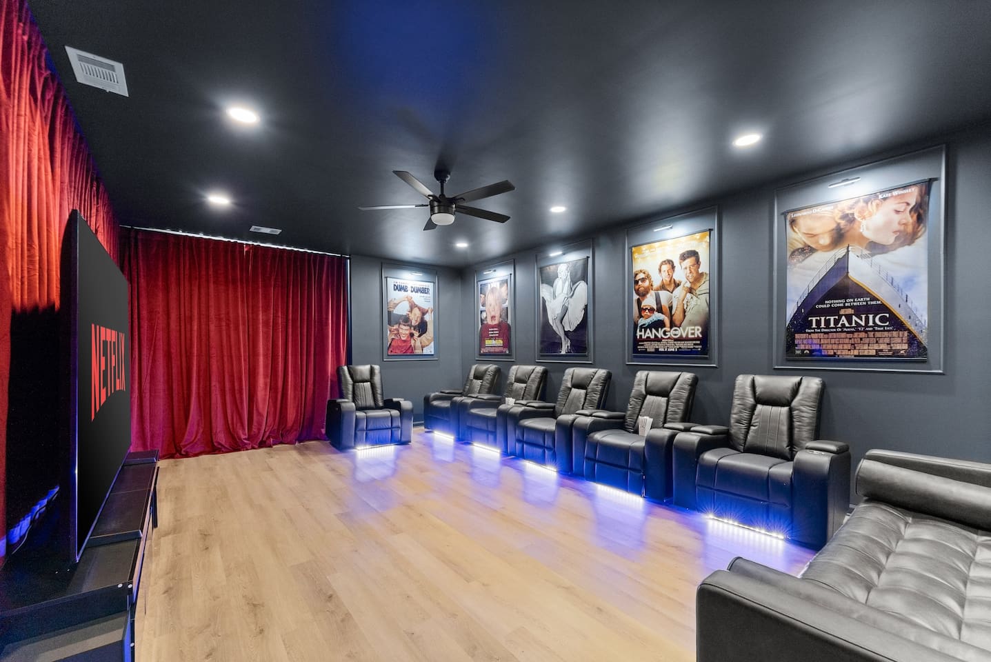 Private theater retreat, featuring comfy theater chairs, a poly and bark couch, and walls adorned with iconic movie classics—from Titanic to The Godfather.