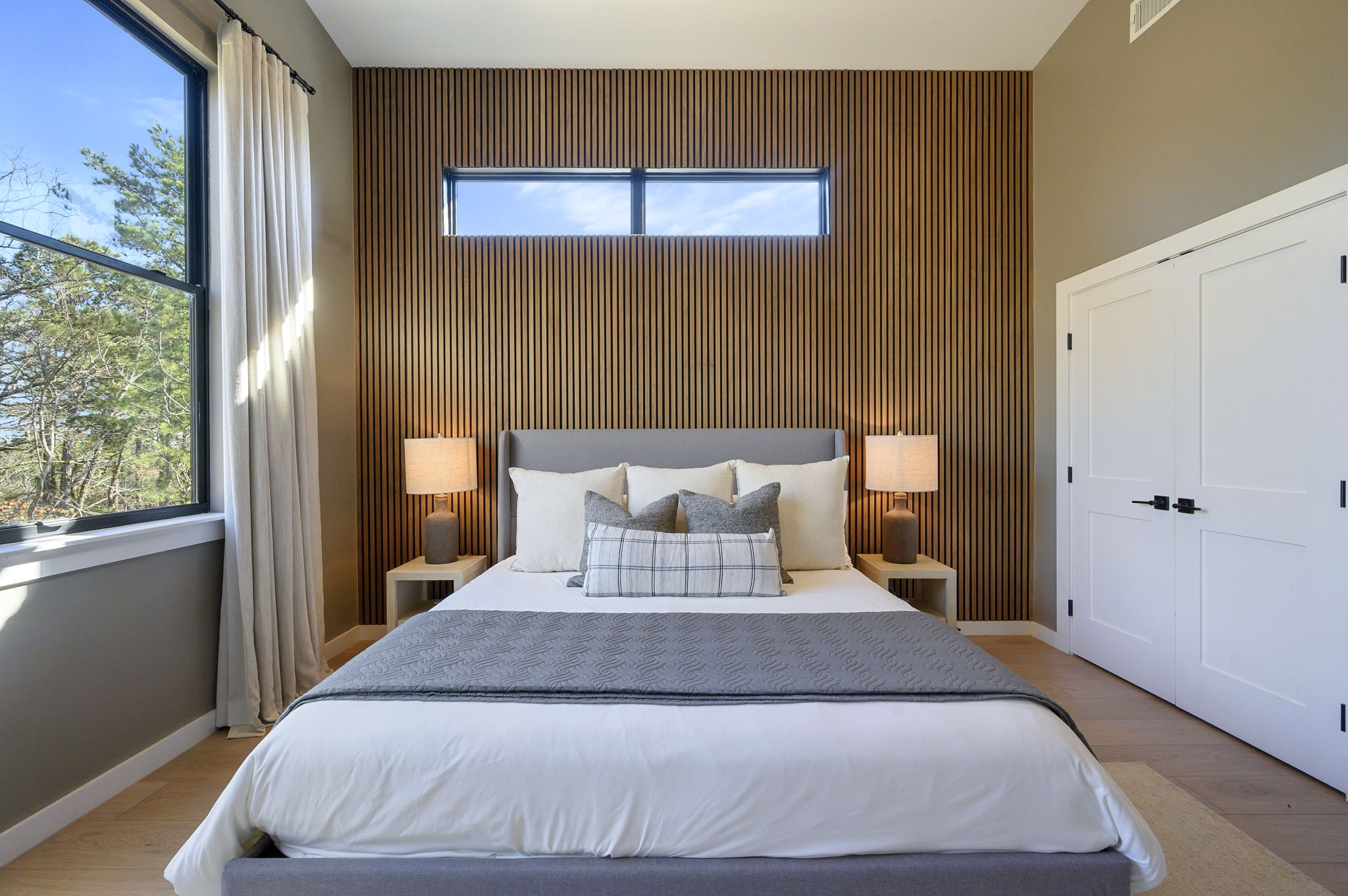 King Suite 2 - Large and spacious suite with teak wood paneling, designer finishes, smart TV, premium king mattress, and luxury bedding. Includes stunning views of the hardwood forest. 