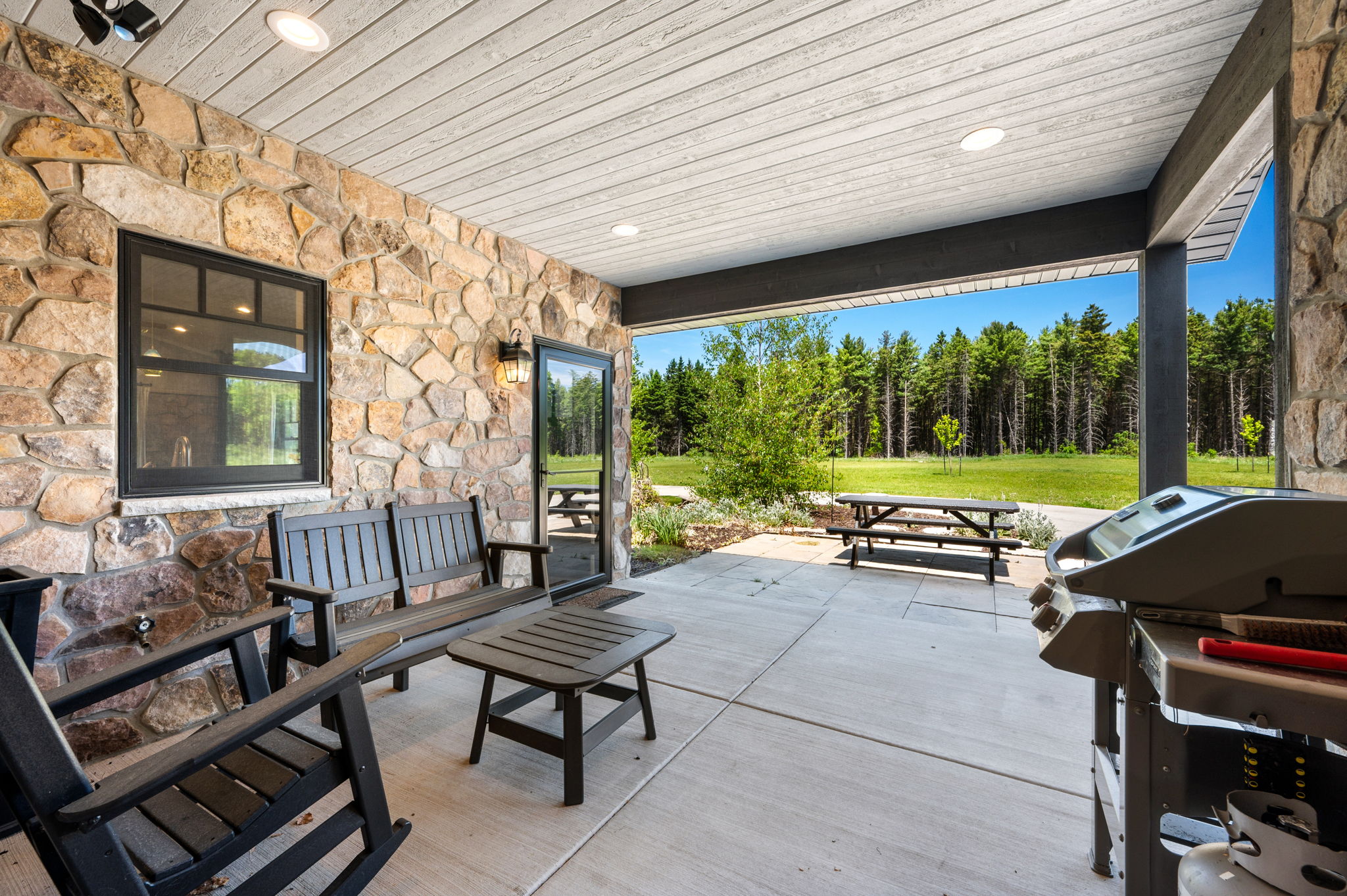 Step outside to the covered patio and take in the picnic table, grill, and unobstructed views of the lush lawn and pine forest.