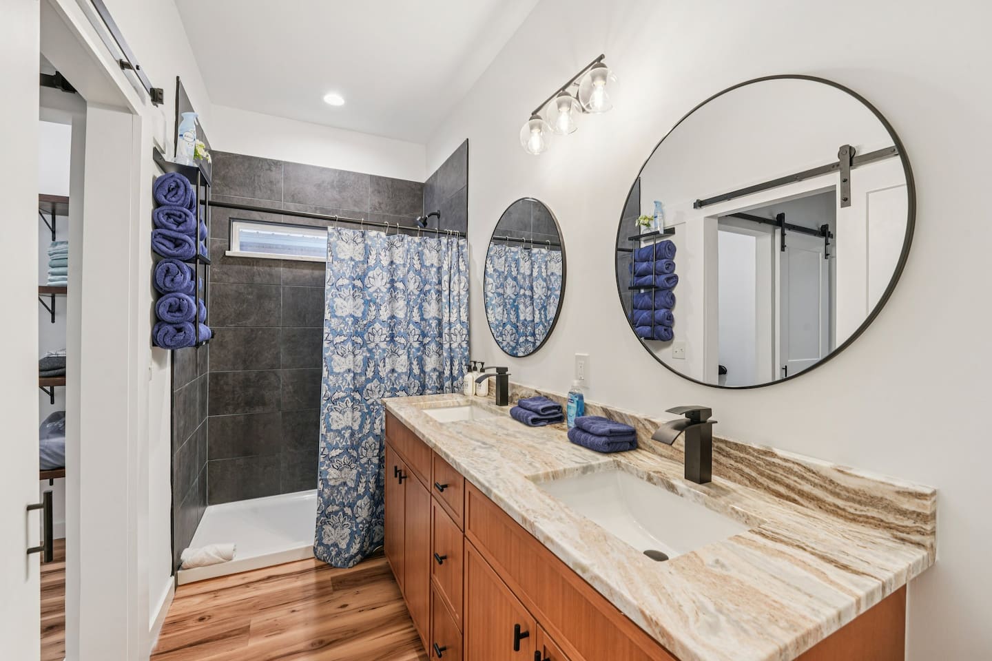 Primary bathroom has double vanity, large walk-in shower, body wash, shampoo, conditioner, plenty of towels, hair dryer, and first aid kit