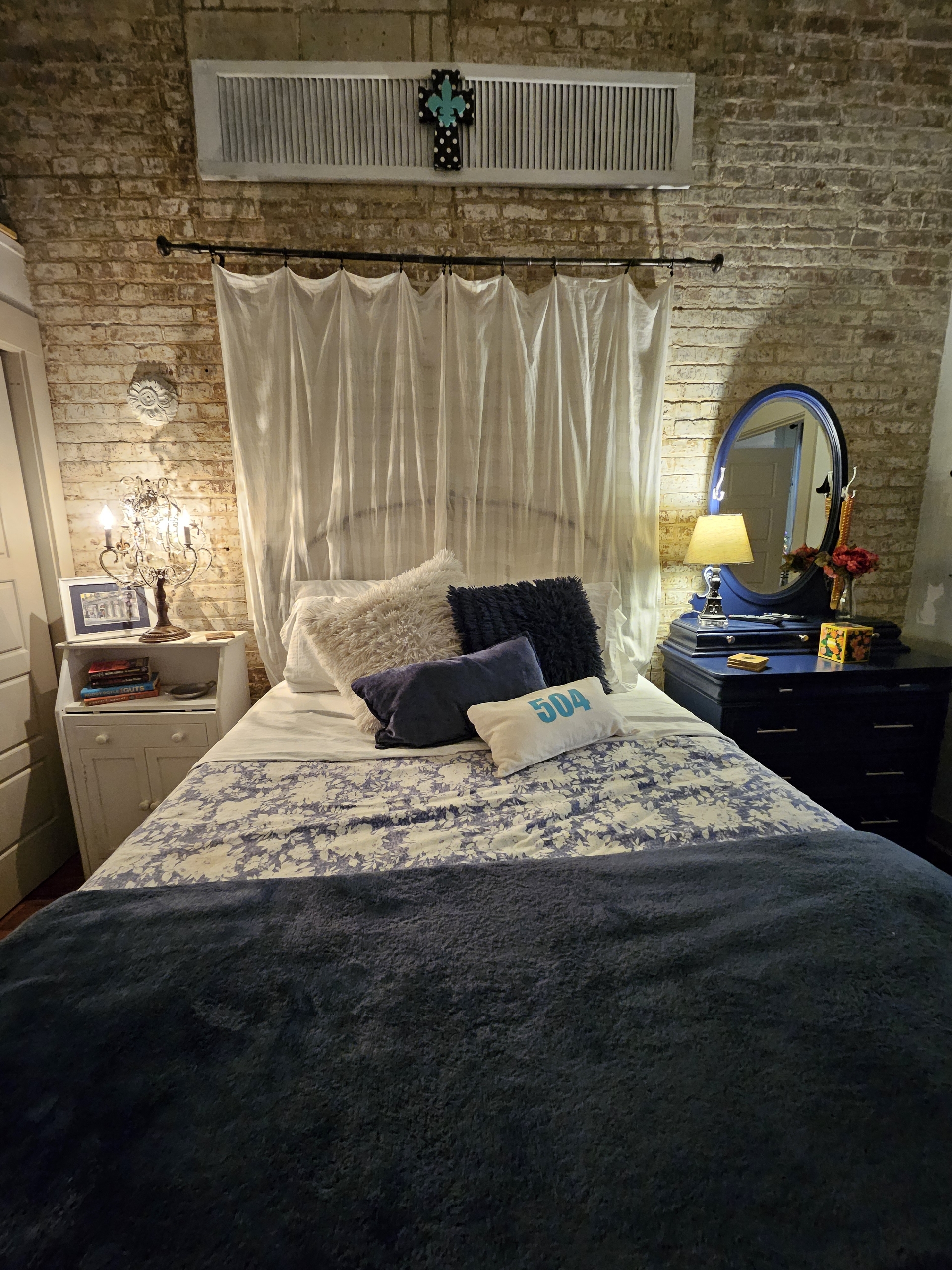 Queen bed (on risers), night stand on left, dresser w/mirror on right. NOT a window behind the drapes.