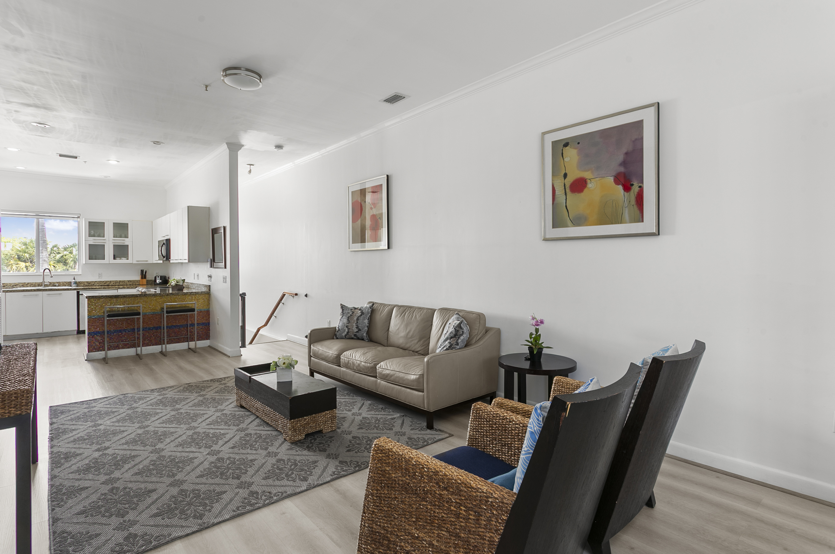 Living room with leather sofa, accent chairs, and a 50-inch flat screen TV.
