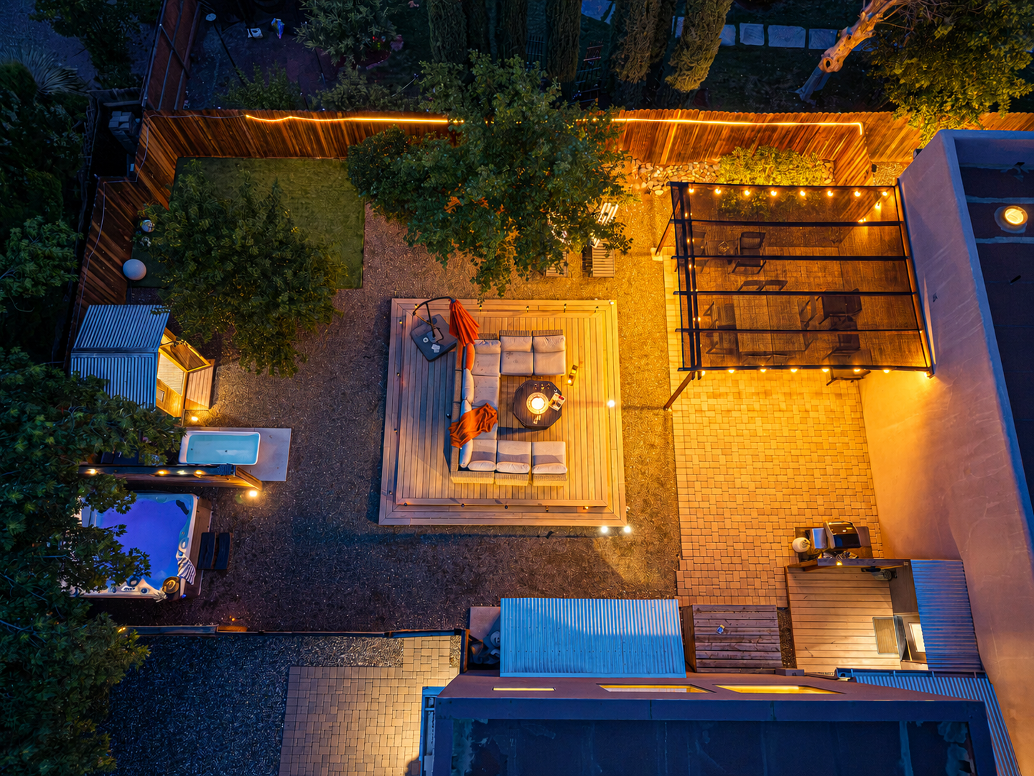 {Outdoor Spaces} An aerial view shows the private backyard, wellness area and multiple outdoor gathering spaces surrounding the home.