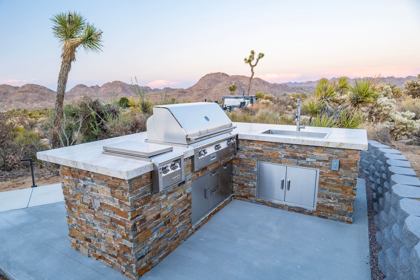 Cook and entertain in style with a fully equipped outdoor kitchen featuring a high-performance Alfresco grill, burners, and sink.