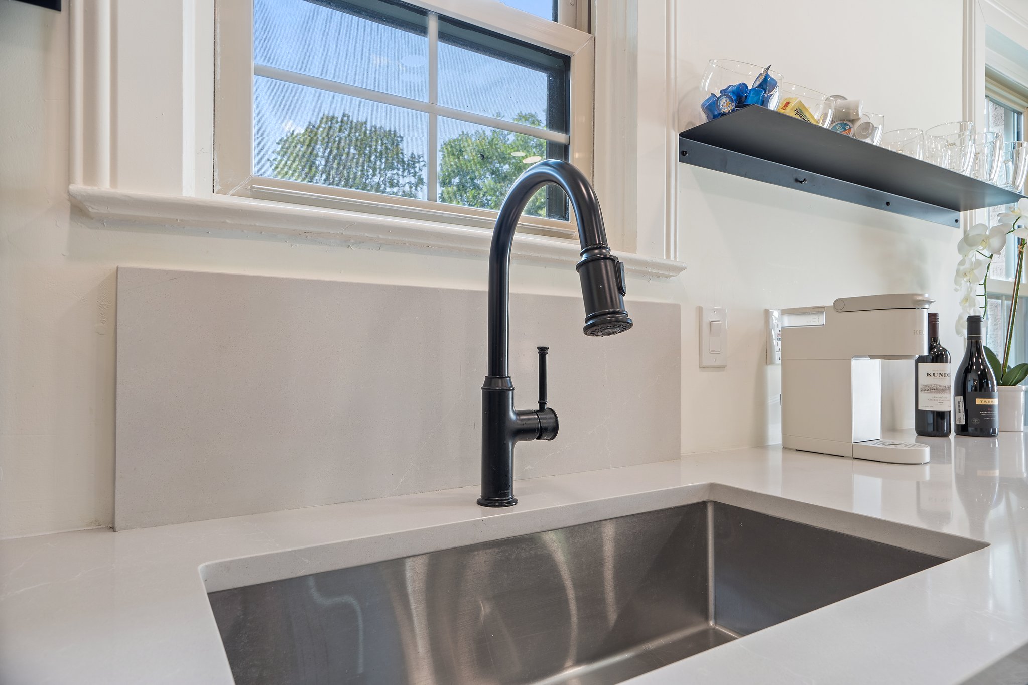 Kitchen matte black undermount sink with quartz countertop and large window. Dishwasher, wine glasses, full cookware, cooking basics, and all kitchen essentials provided. Main house, first floor.