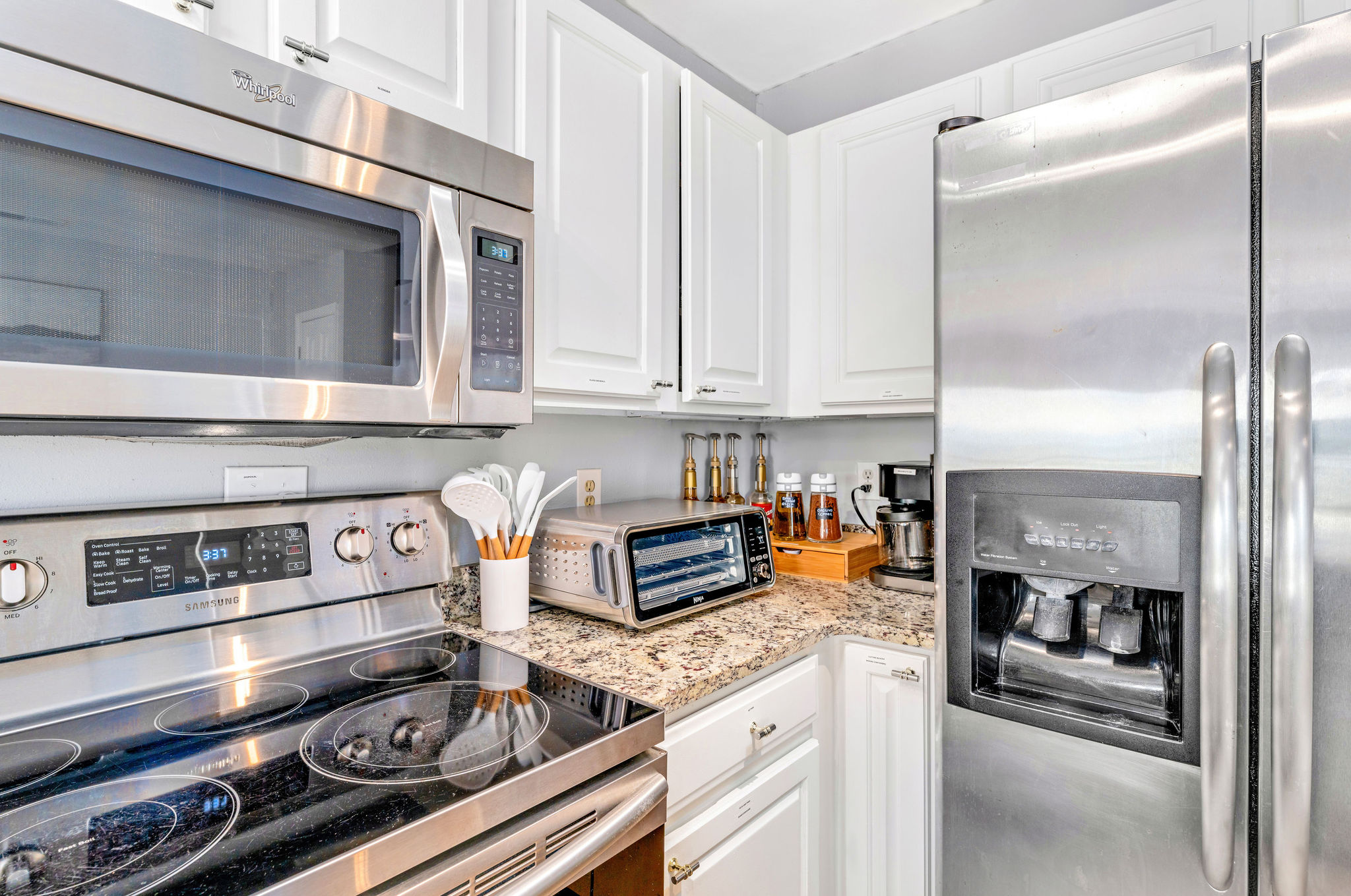 The kitchen features stainless steel appliances that enhance its modern appeal. It includes an air fryer for convenient and healthy cooking, as well as a Keurig Duo coffee maker to easily brew your favorite beverages.