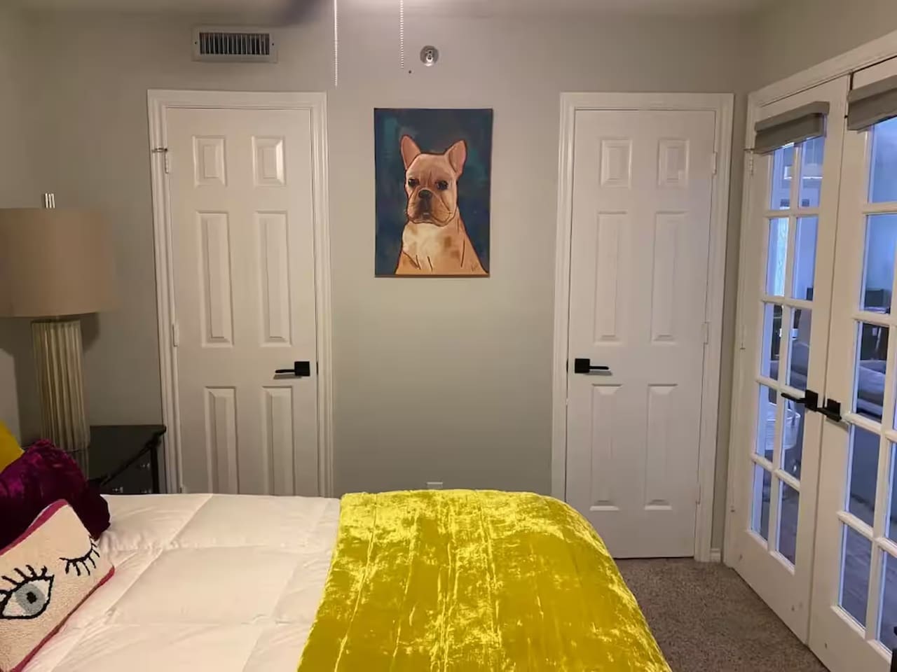 Bedroom with queen bed and bold yellow bedding.