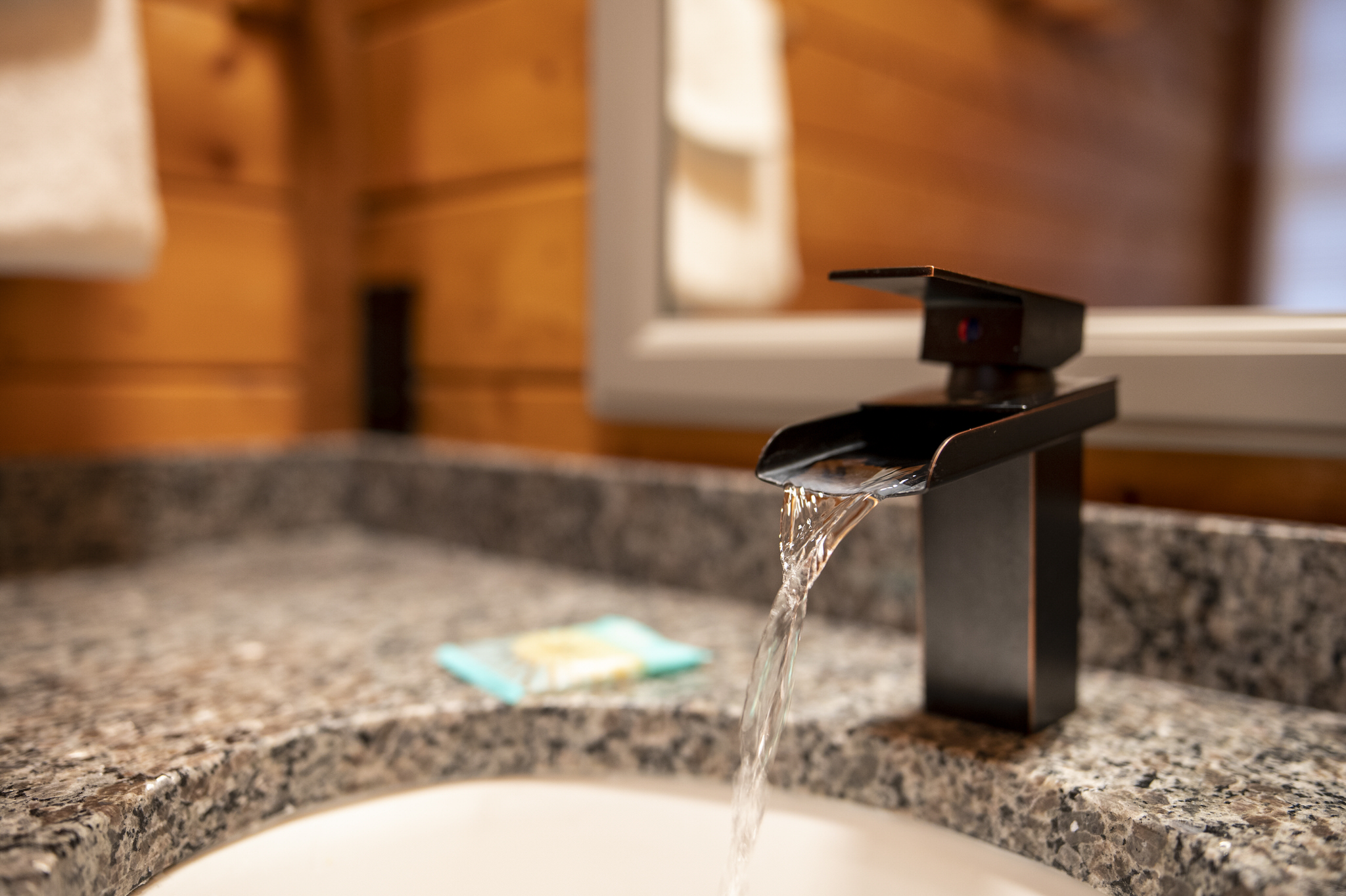 Modern vanity with granite counter and sleek black faucet.