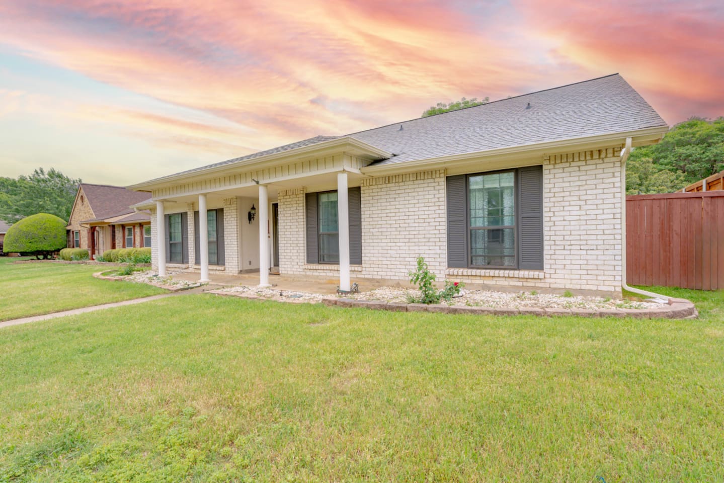 Welcoming curb appeal with manicured lawn and covered entry.