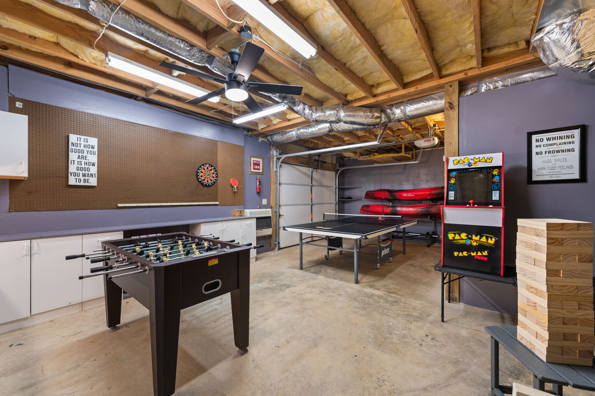 The converted garage game room is packed with fun, offering table tennis, arcade games, foosball, and darts for endless entertainment.