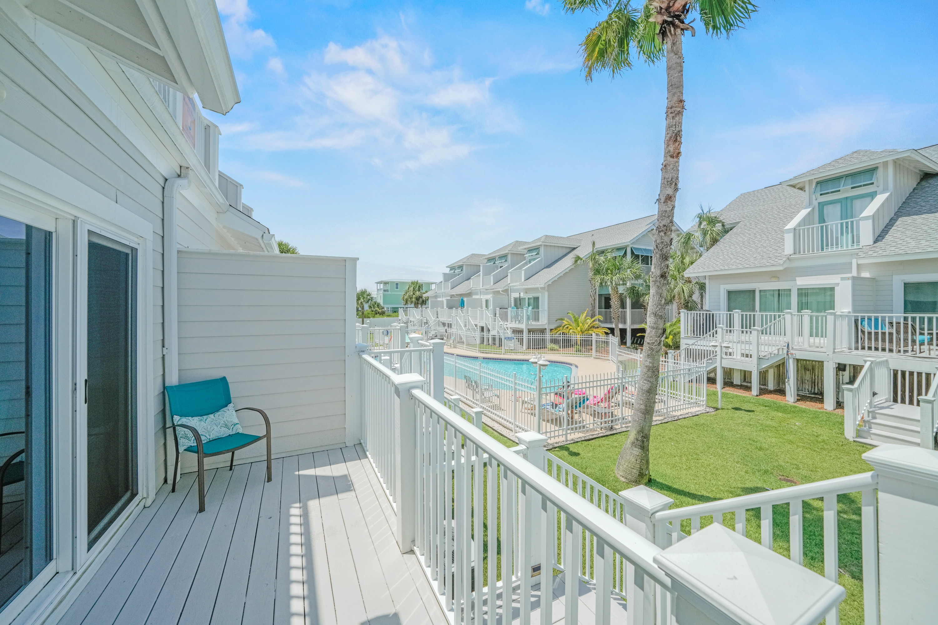 Bright balcony with comfortable seating overlooking the pool area