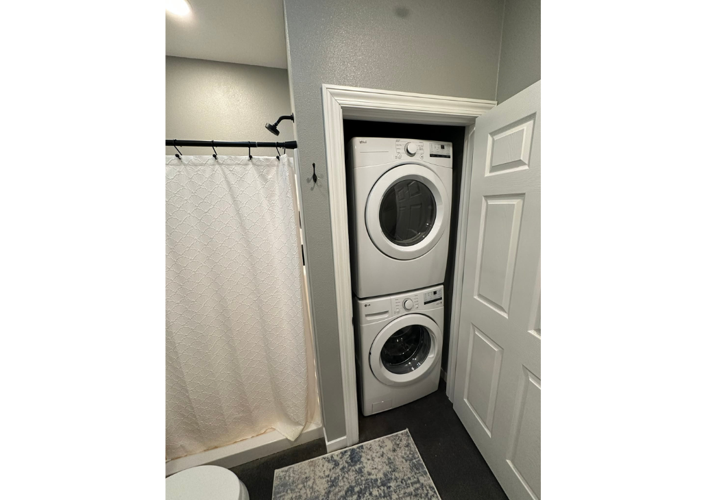 Bathroom 2 view with the washer and dryer next to the stand up shower.