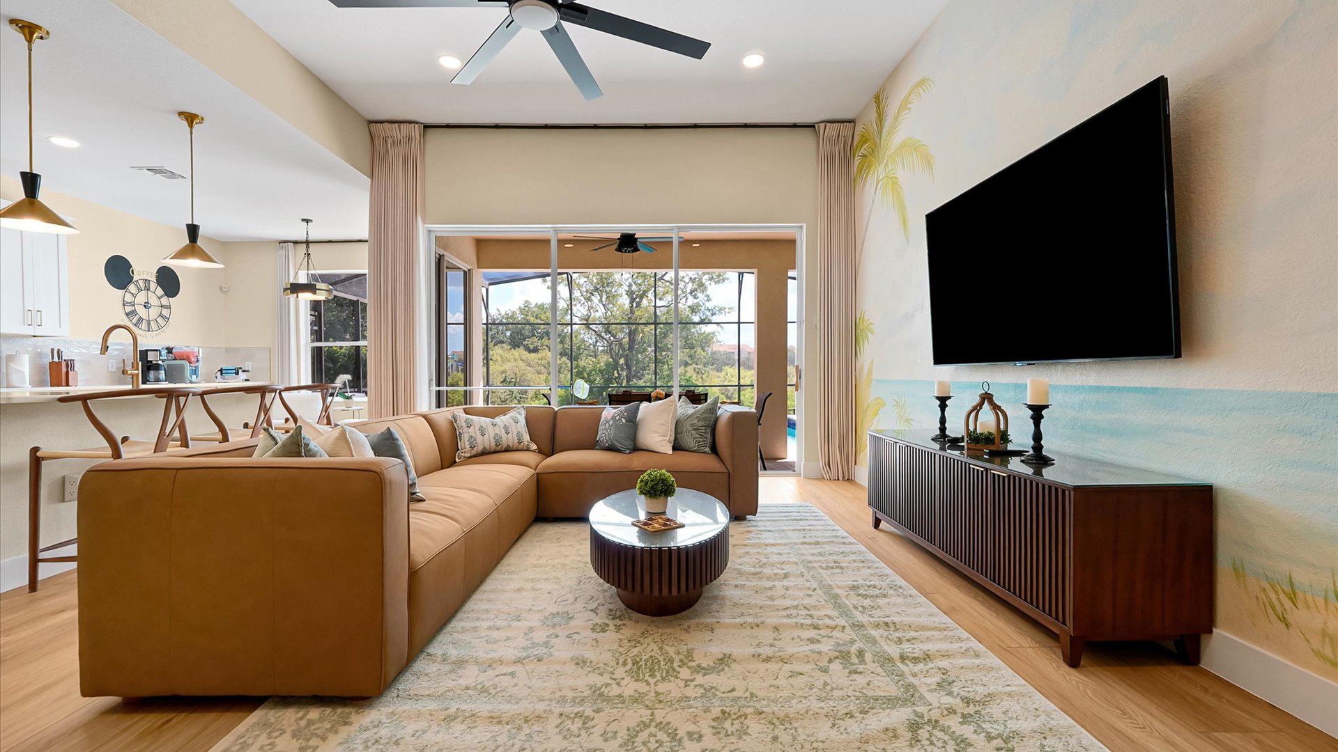 Living Room: Comfortable family gathering space with a large TV, hand-painted tropical mural and peaceful conservation views.