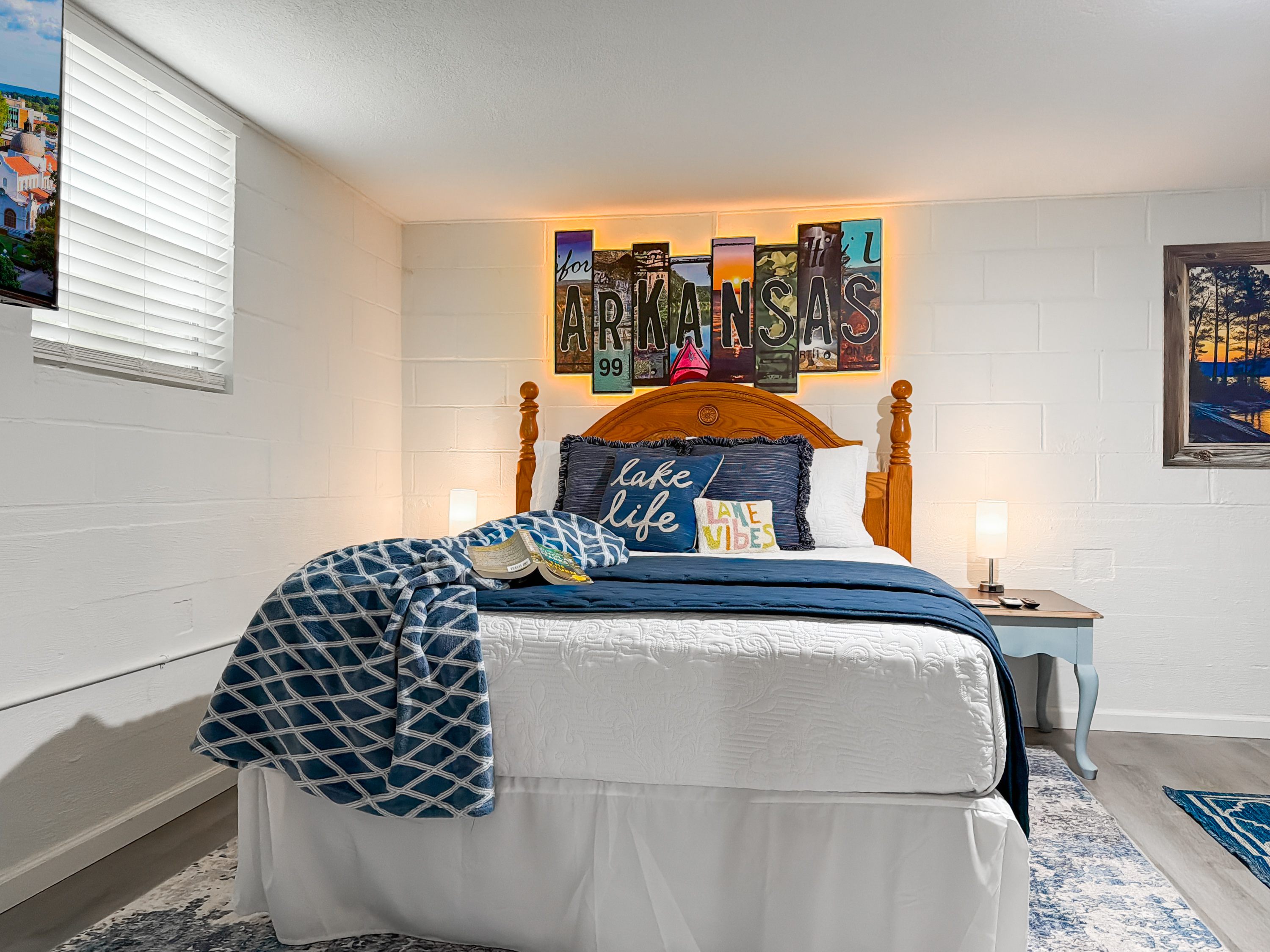 Bunk down in the Arkansas-themed queen — 'lake life' on the wall and a smart TV of its own.