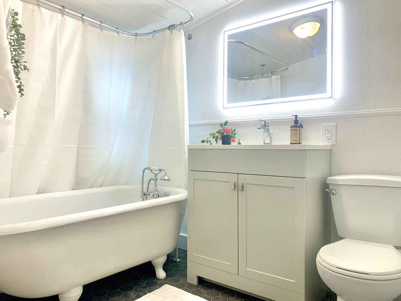 Full bathroom with the original refinished clawfoot soaker tub, hand held shower nozzle, vanity, and fresh towels provided. 