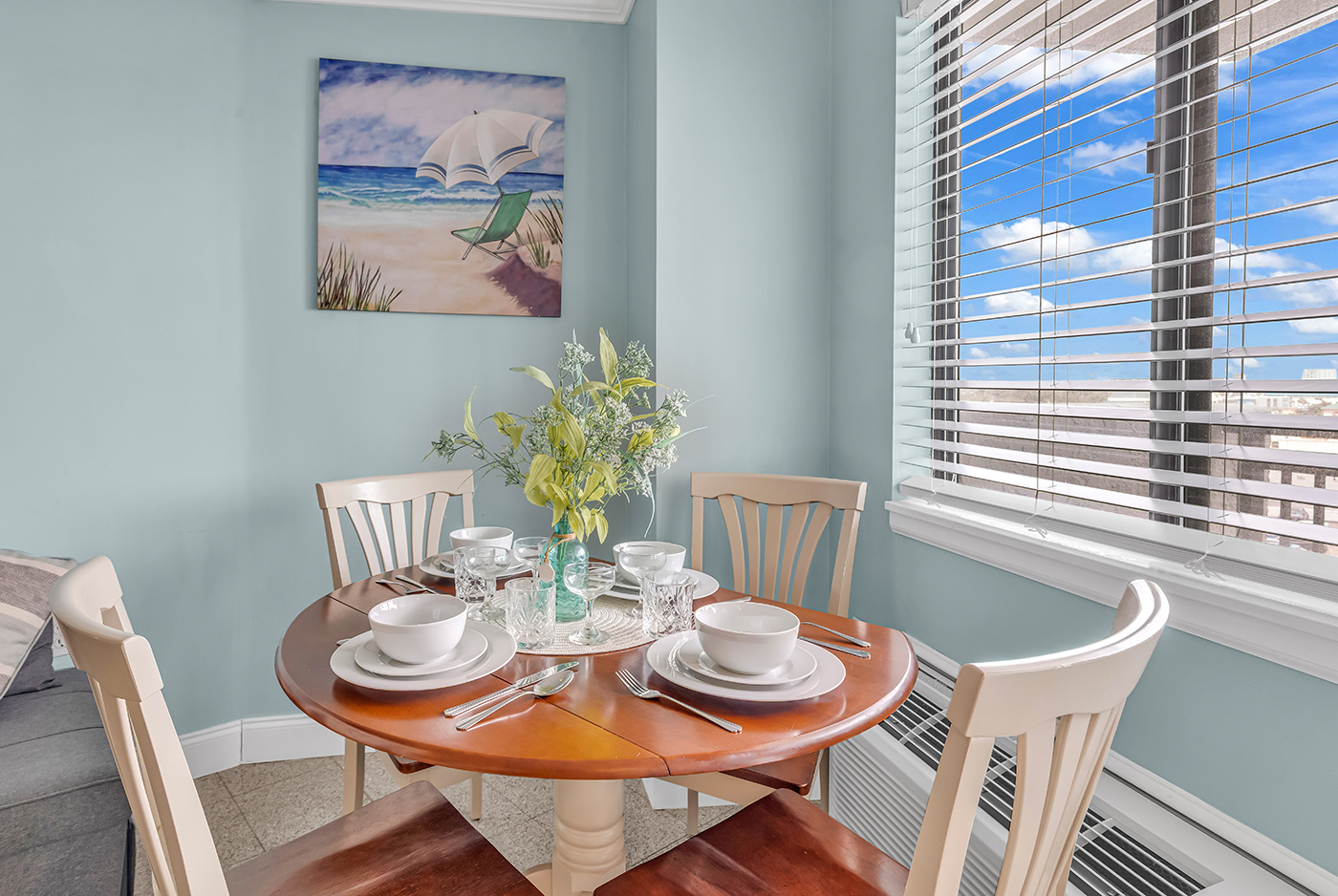 Dining table for 4 beside a large window with natural light and ocean views