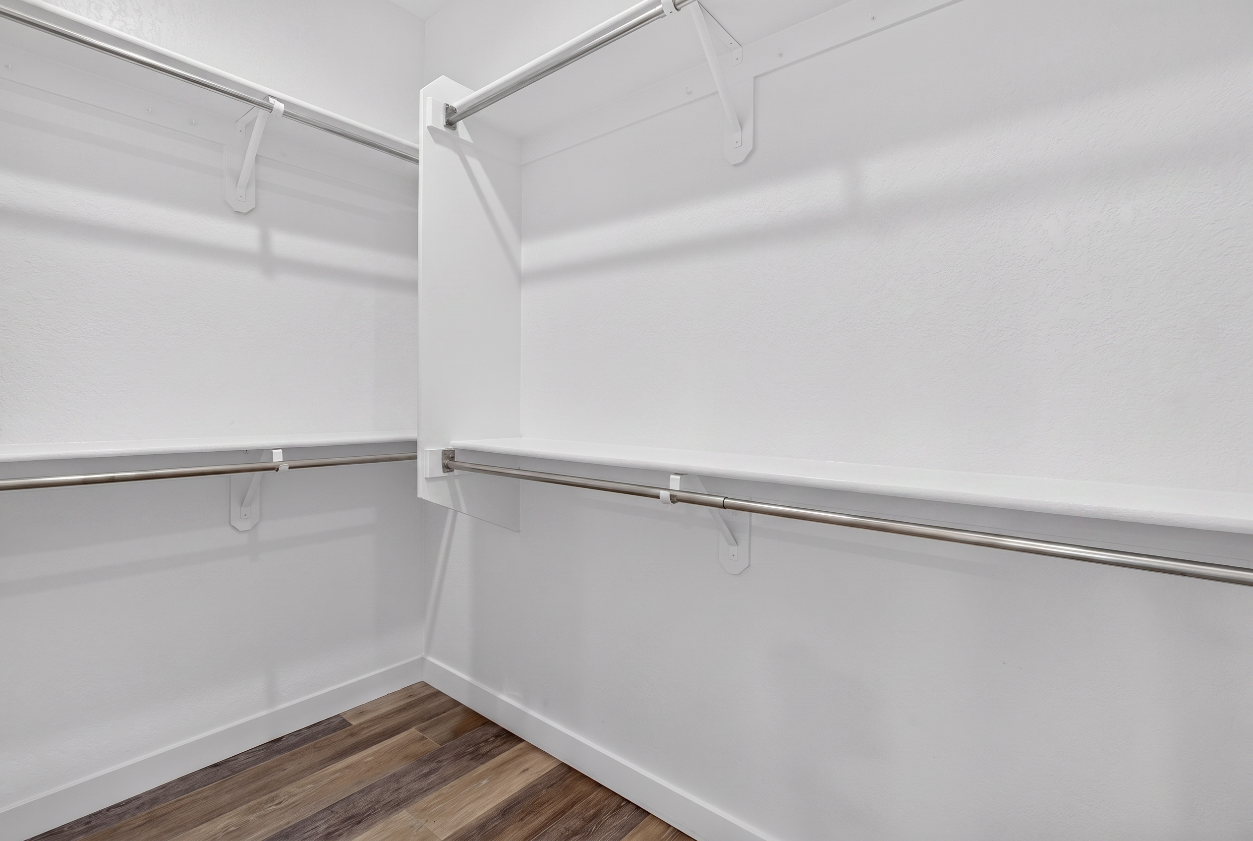 Walk-in closet with hanging rods, open shelving, and room to unpack or store luggage during your stay.