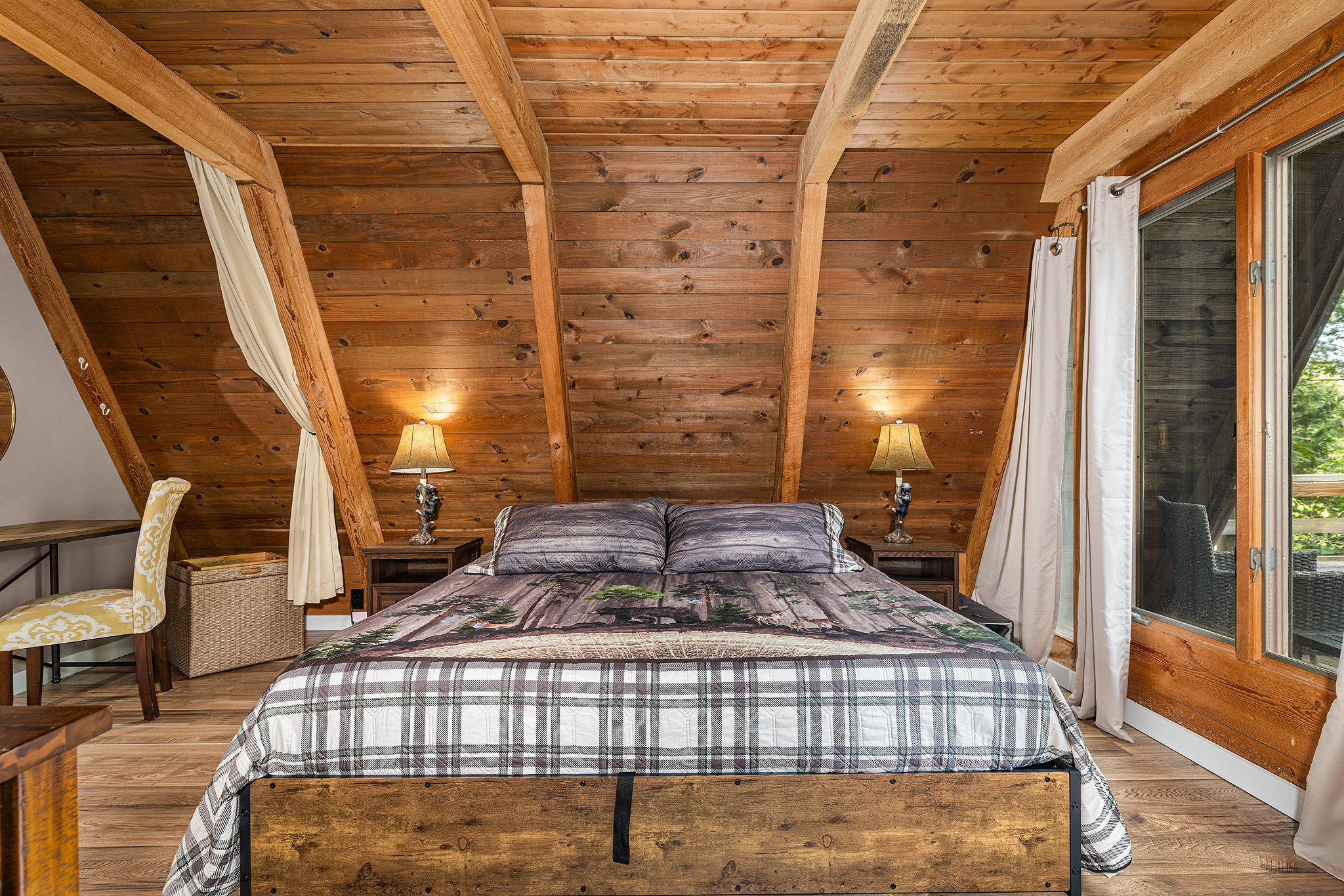 Discover the first-floor sleeping space with king bed flanked by beside tables.
