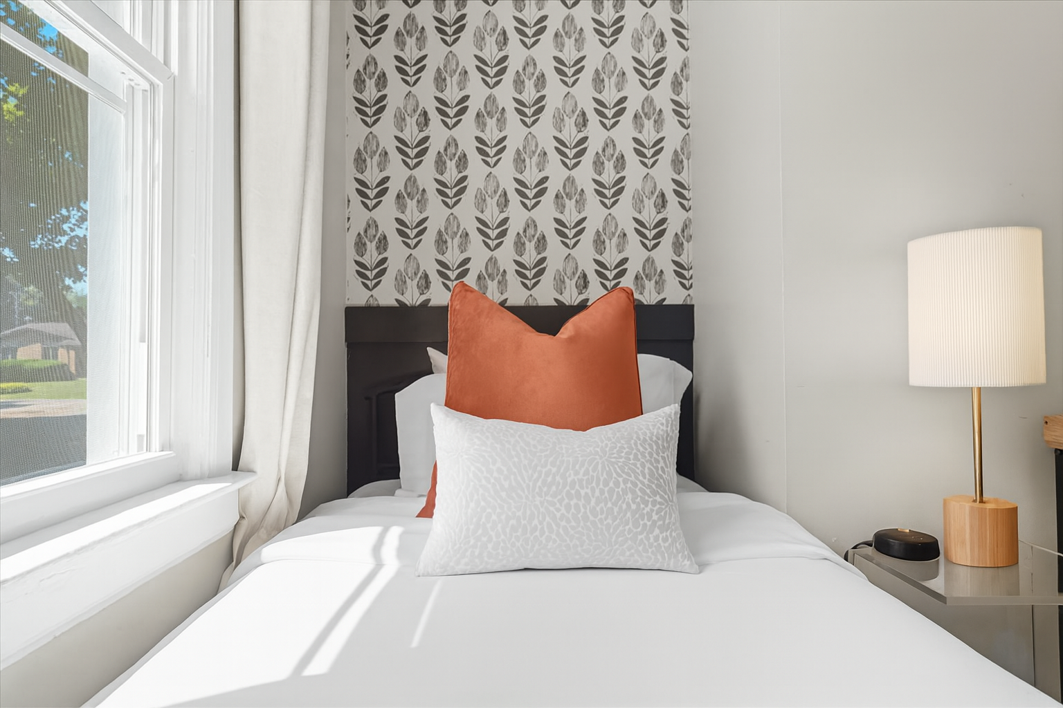 Stylish bedroom with patterned accent wall and cozy touches