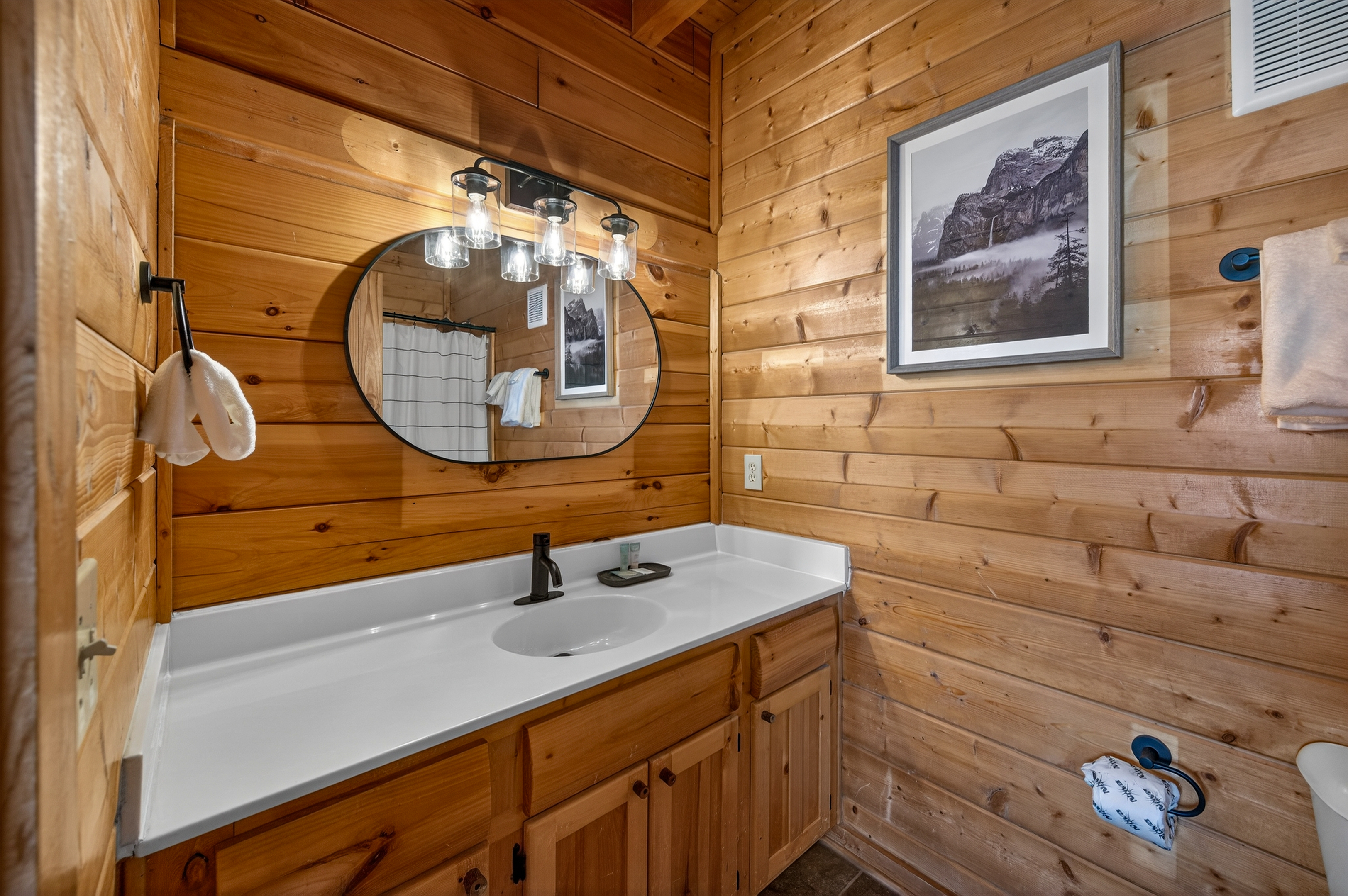 Main level en-suite bathroom — fresh towels, shampoo, conditioner, and body soap stocked for every guest.