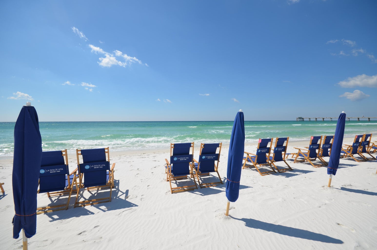 Sandy beach setup w/ chairs facing the water, made for long seaside days.