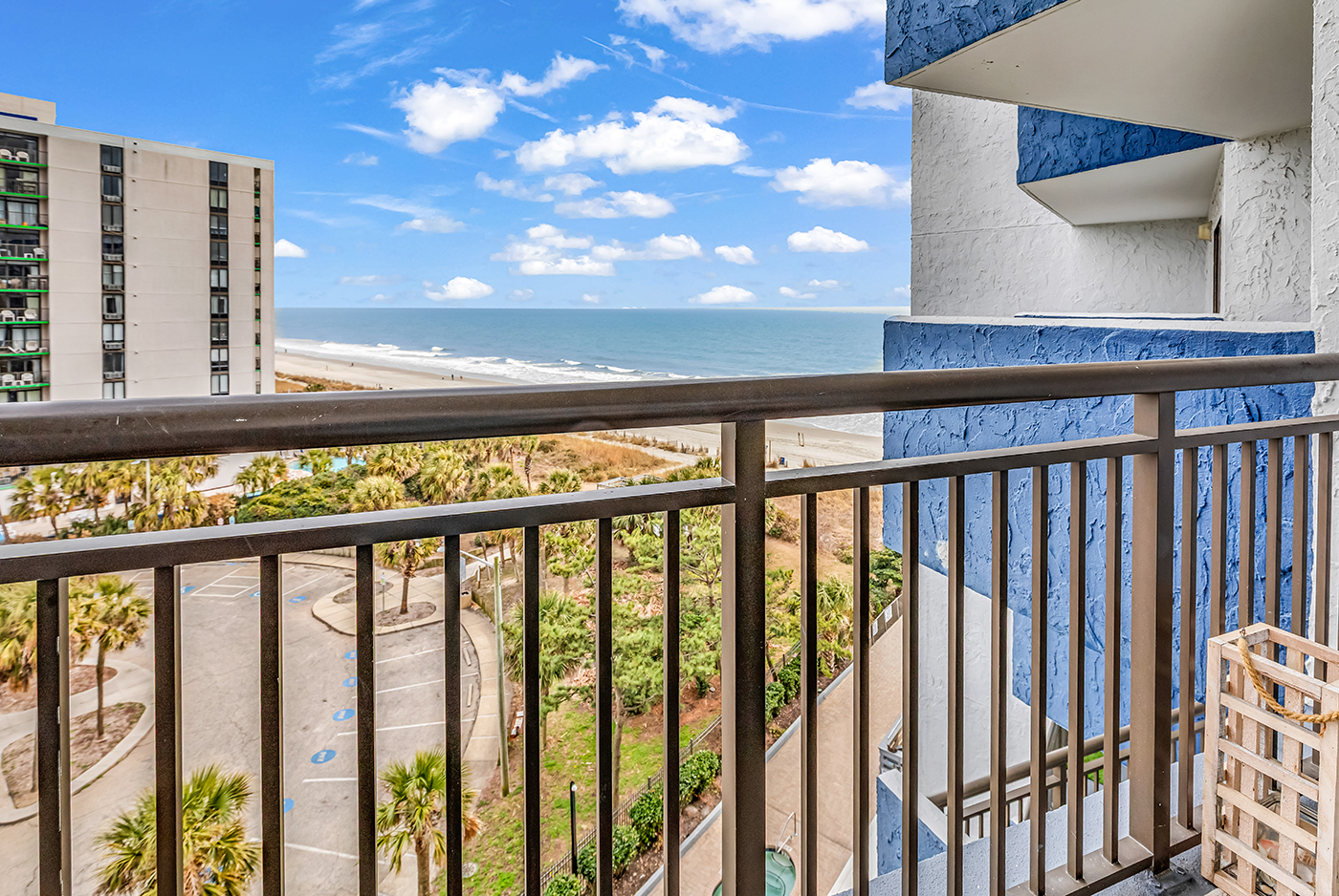 Balcony view overlooking the pool, palm trees, and Atlantic Ocean — enjoy the fresh sea air from your private outdoor space