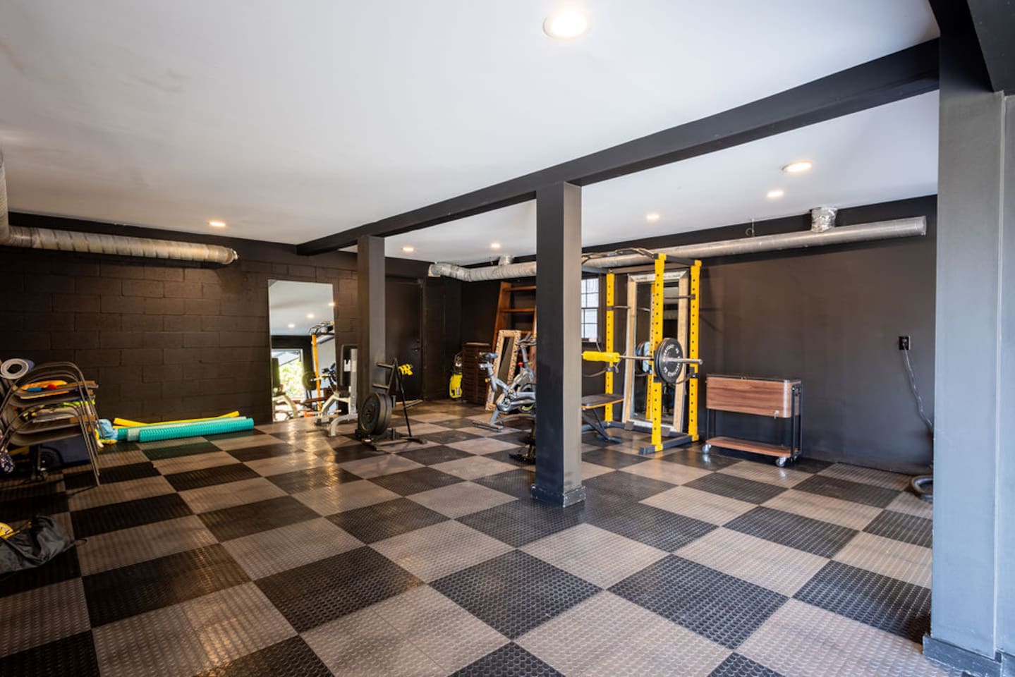 Well-equipped gym featuring a variety of fitness machines and free weights, offering a convenient space to stay active and maintain your workout routine.
