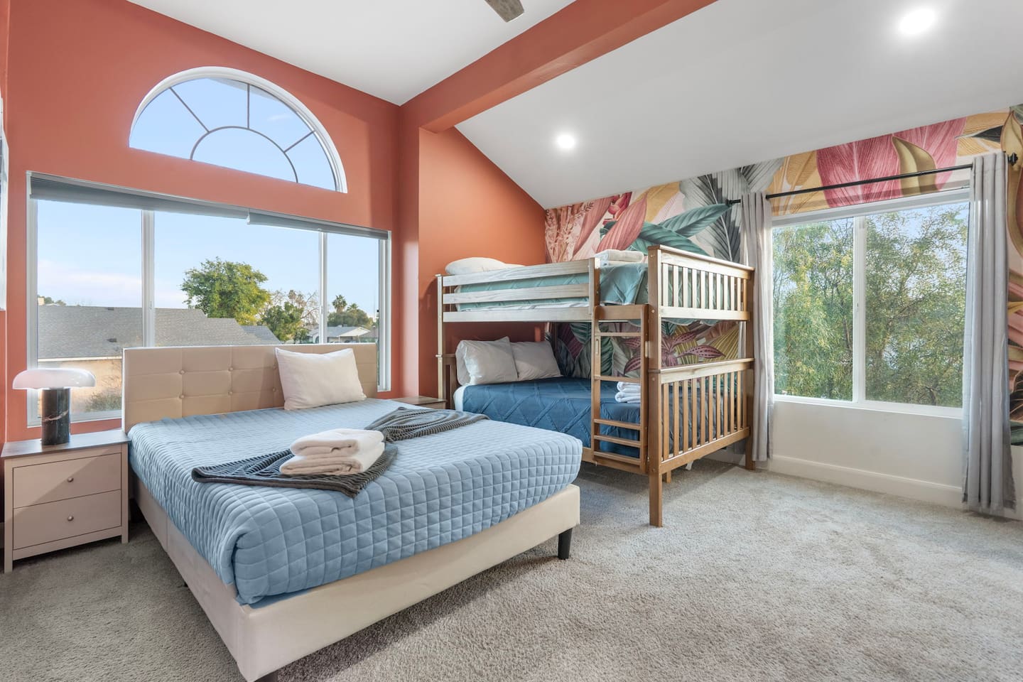 Bright, cheerful kids' bedroom with queen bed, bunk beds, and plenty of natural light for family groups.