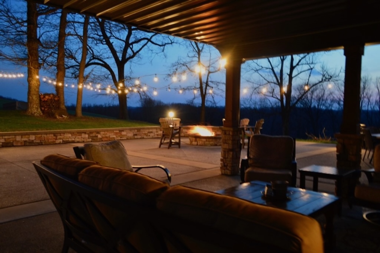 Relax under the covered patio with views of the fire pit and string lights