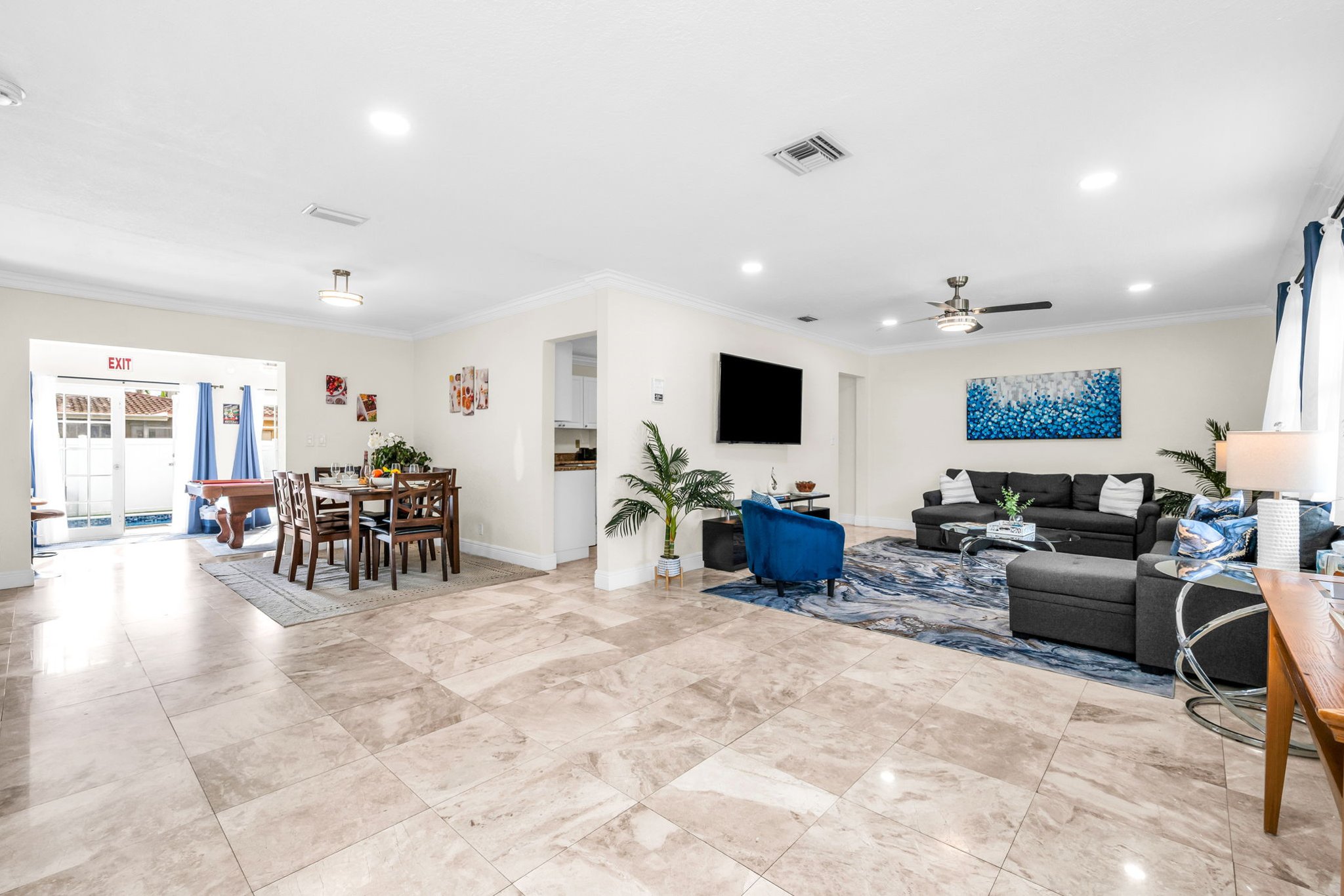 Large family-friendly living room with two queen pull-out sofas, flat-screen smart TV, and stylish coastal décor—great for groups needing extra sleeping options.