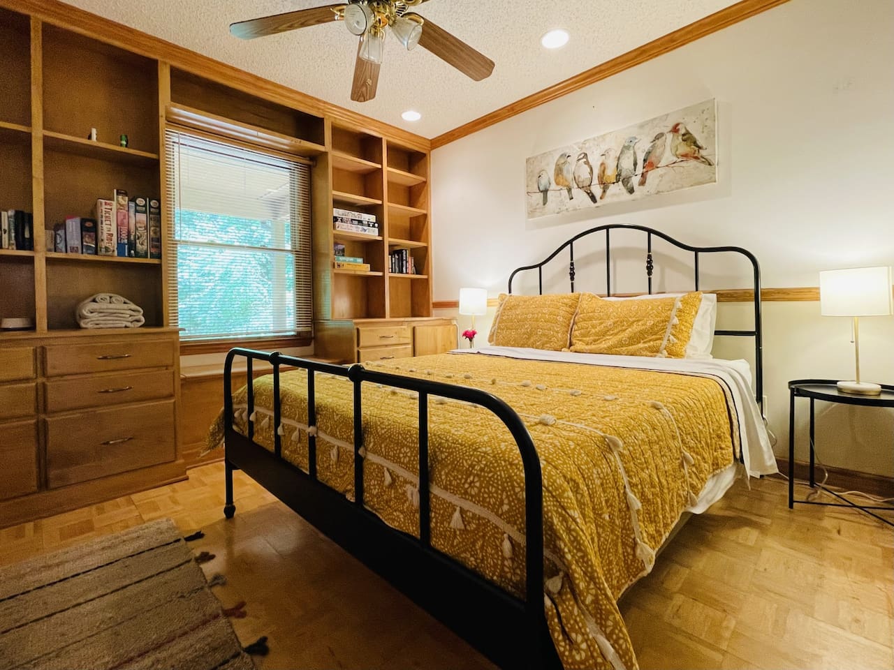 Cheery and comfortable main floor bedroom has a queen bed and a book nook with games and puzzles