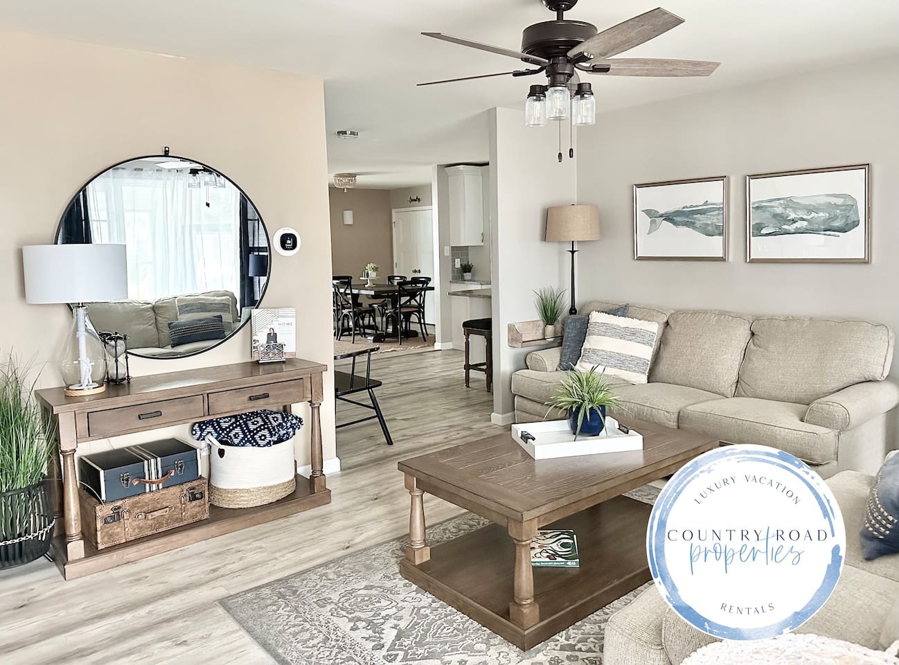 Relax in our modern farmhouse living room featuring a plush sectional, rustic wood accents, and coastal decor. This open-concept space flows into the dining area, perfect for movie nights or morning coffee in a bright, airy atmosphere.
