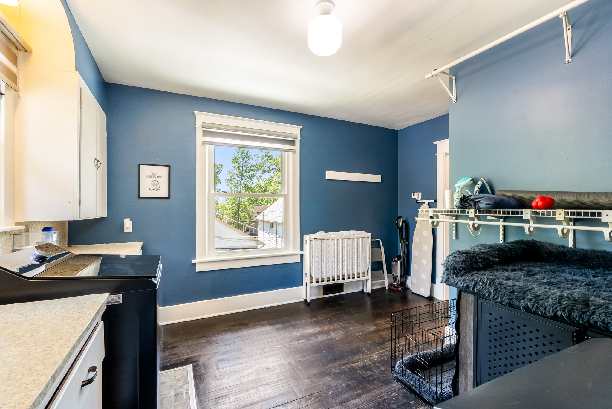 Fully equipped upper-floor laundry room featuring a large-capacity washer and dryer, iron, and a dedicated pet station with 2 crates for our four-legged guests.