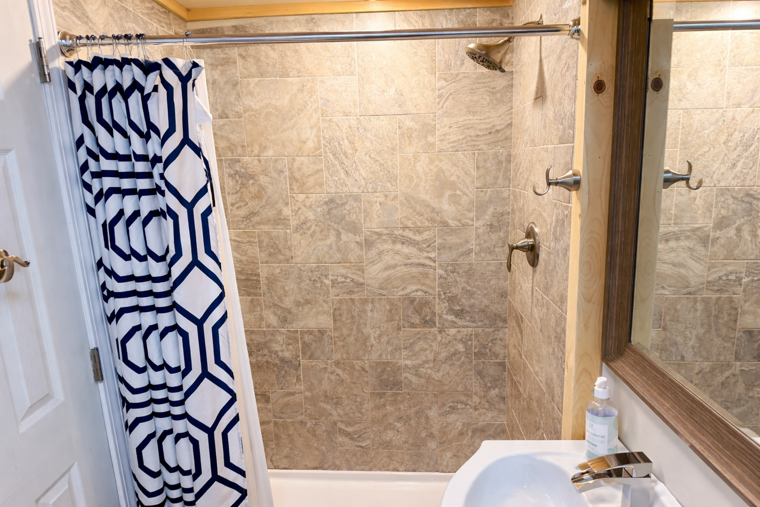 Check out the modern walk-in shower in the basement bathroom, with fresh tile and a clean, updated look.