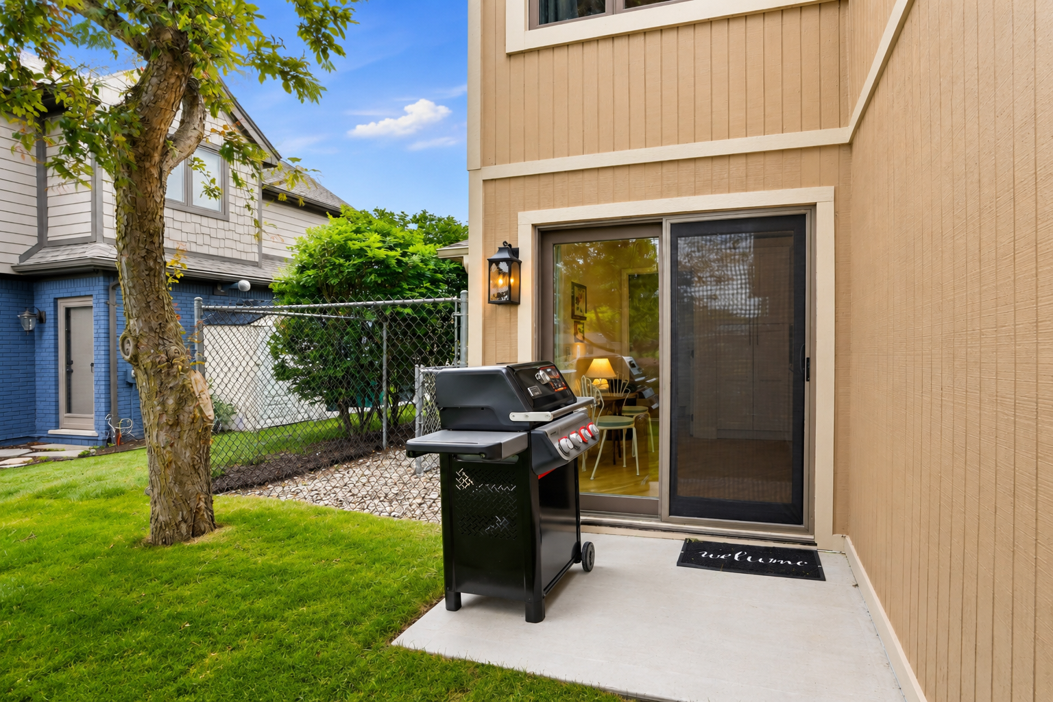 Private outdoor grilling area with a modern BBQ setup and direct walkout access. Clean, functional space ideal for cooking, casual outdoor meals, and enjoying the backyard setting.