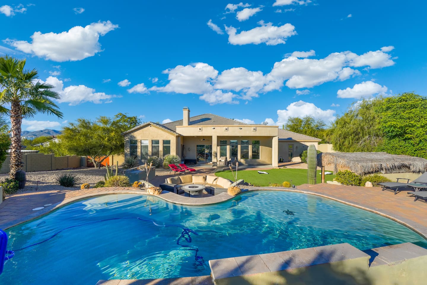 Resort-style pool with a curved design, clear water, and desert landscaping all around.