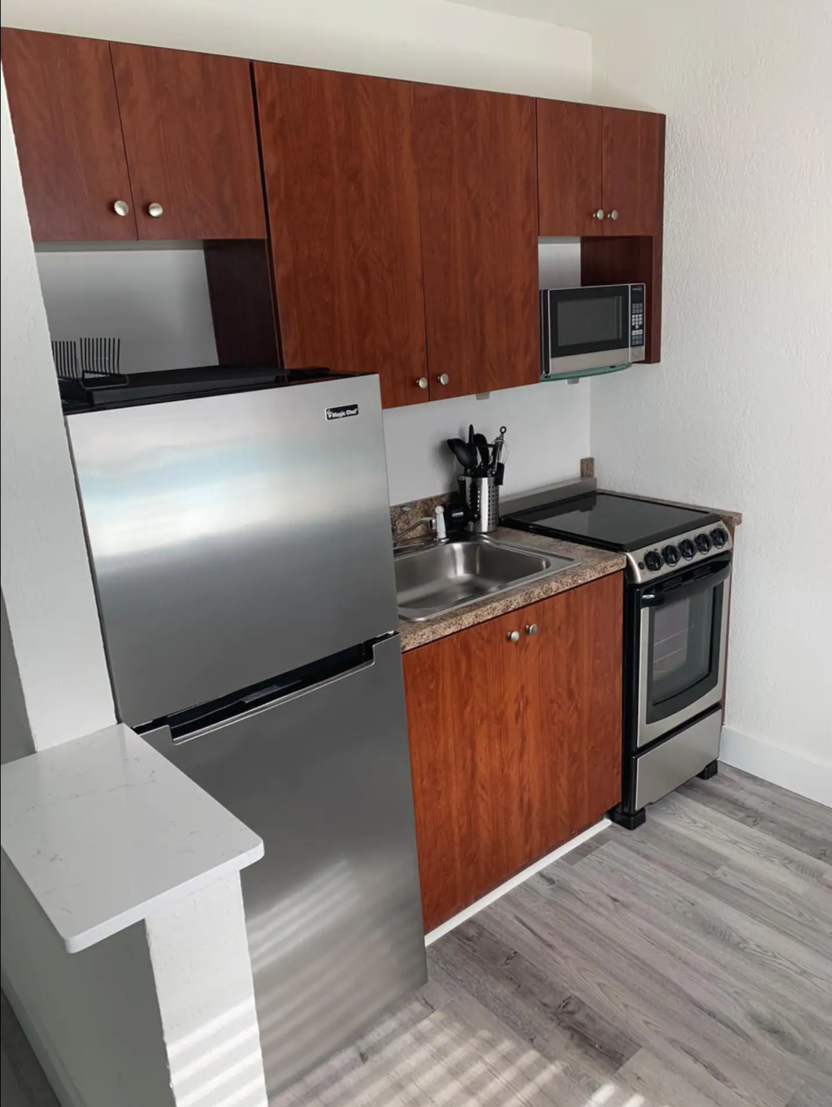 Fully stocked kitchen with stainless steel appliances.