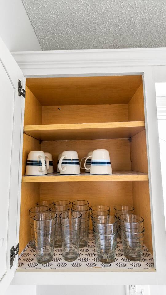 Neatly organized with classic mugs and plenty of glassware—everything you need for your morning coffee or an evening drink.

