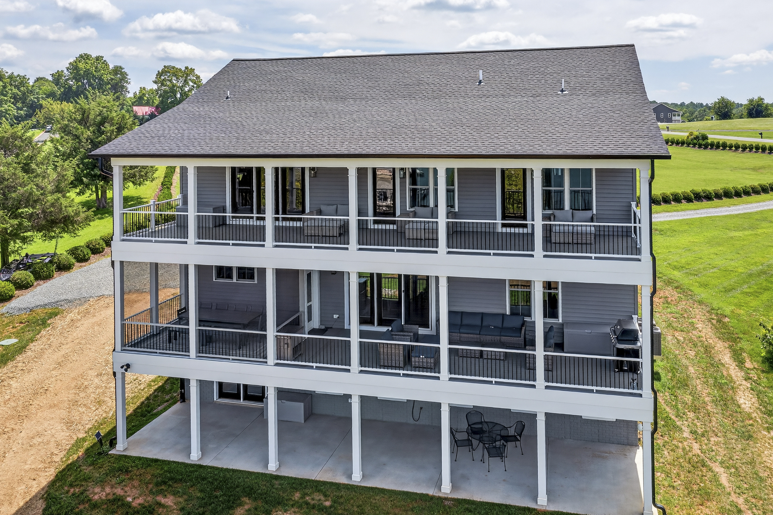 Stunning three-level lakefront home with expansive wraparound decks on both upper floors, offering multiple outdoor living spaces to soak in panoramic views of the water.
