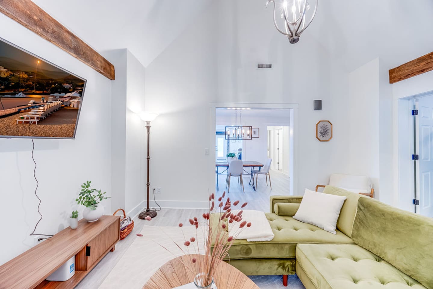Stylish living room with a plush couch, modern TV, and elegant decor, seamlessly connected to the dining area for an open, airy feel.