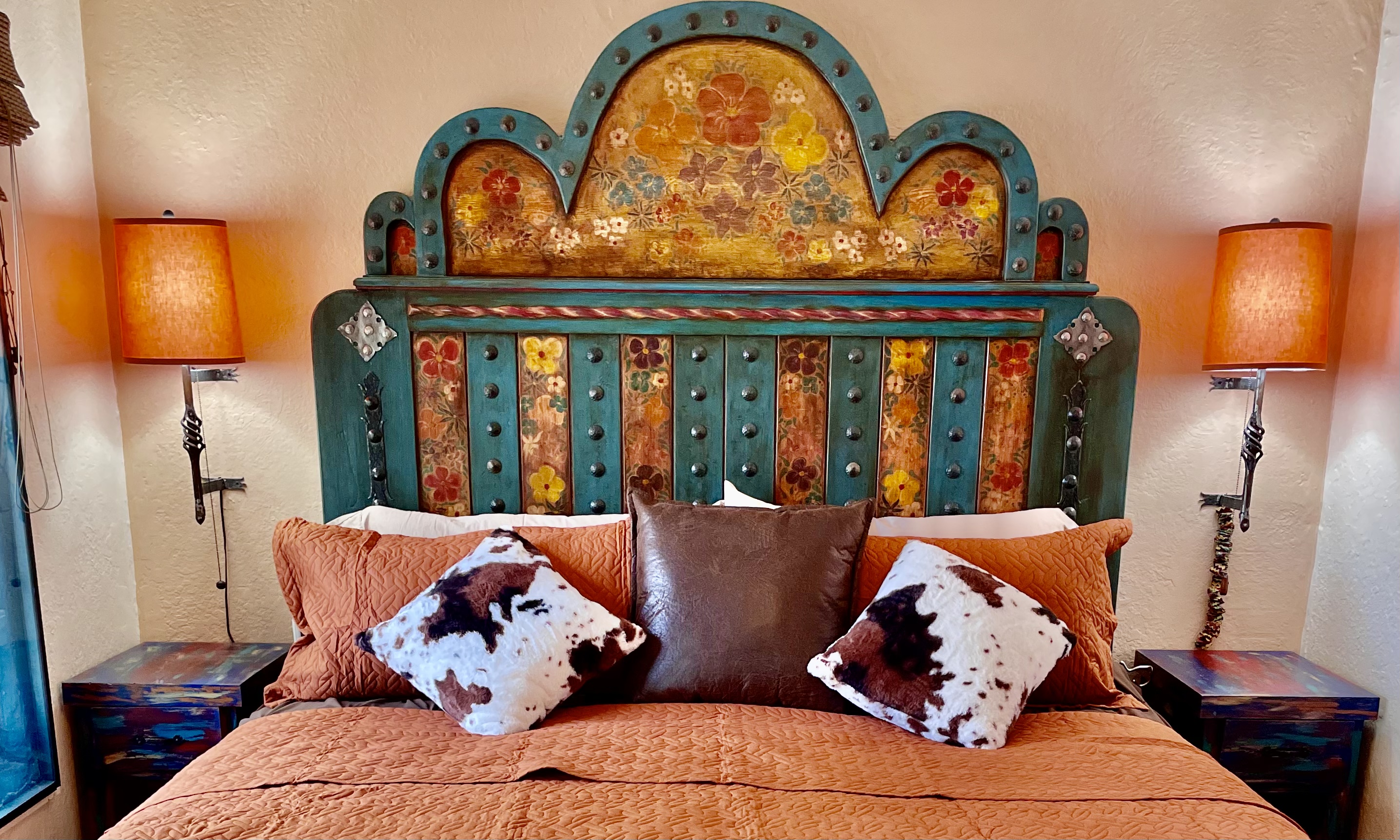 King-size bed with vibrant textiles and artistic accents.