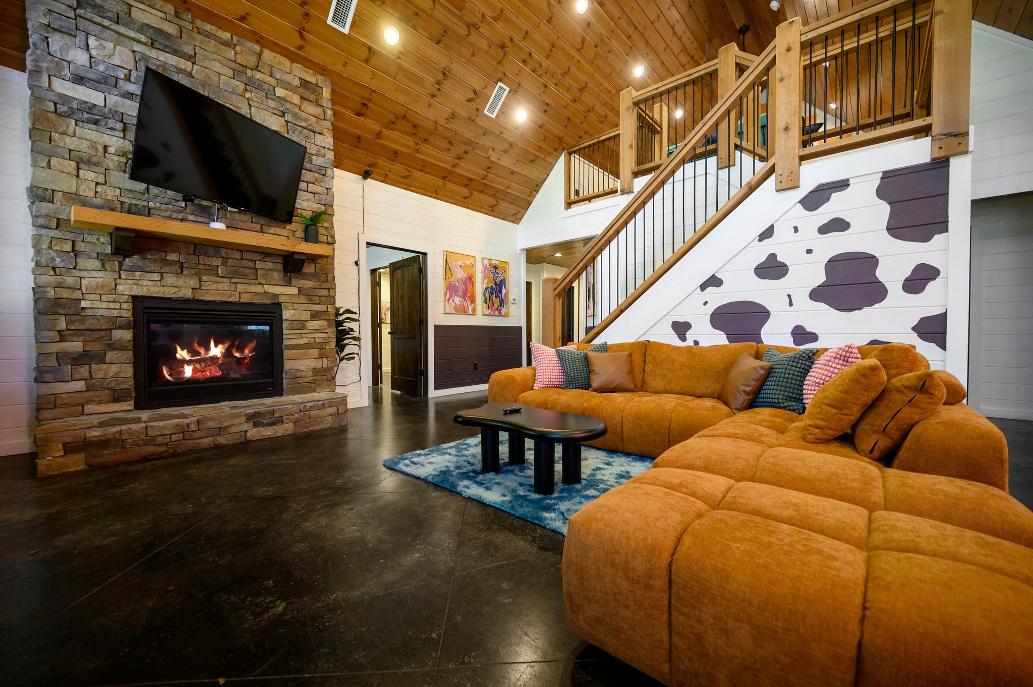 Spacious living room with a stunning stone fireplace, an ultra-comfy couch, and a Smart TV for all your entertainment needs.