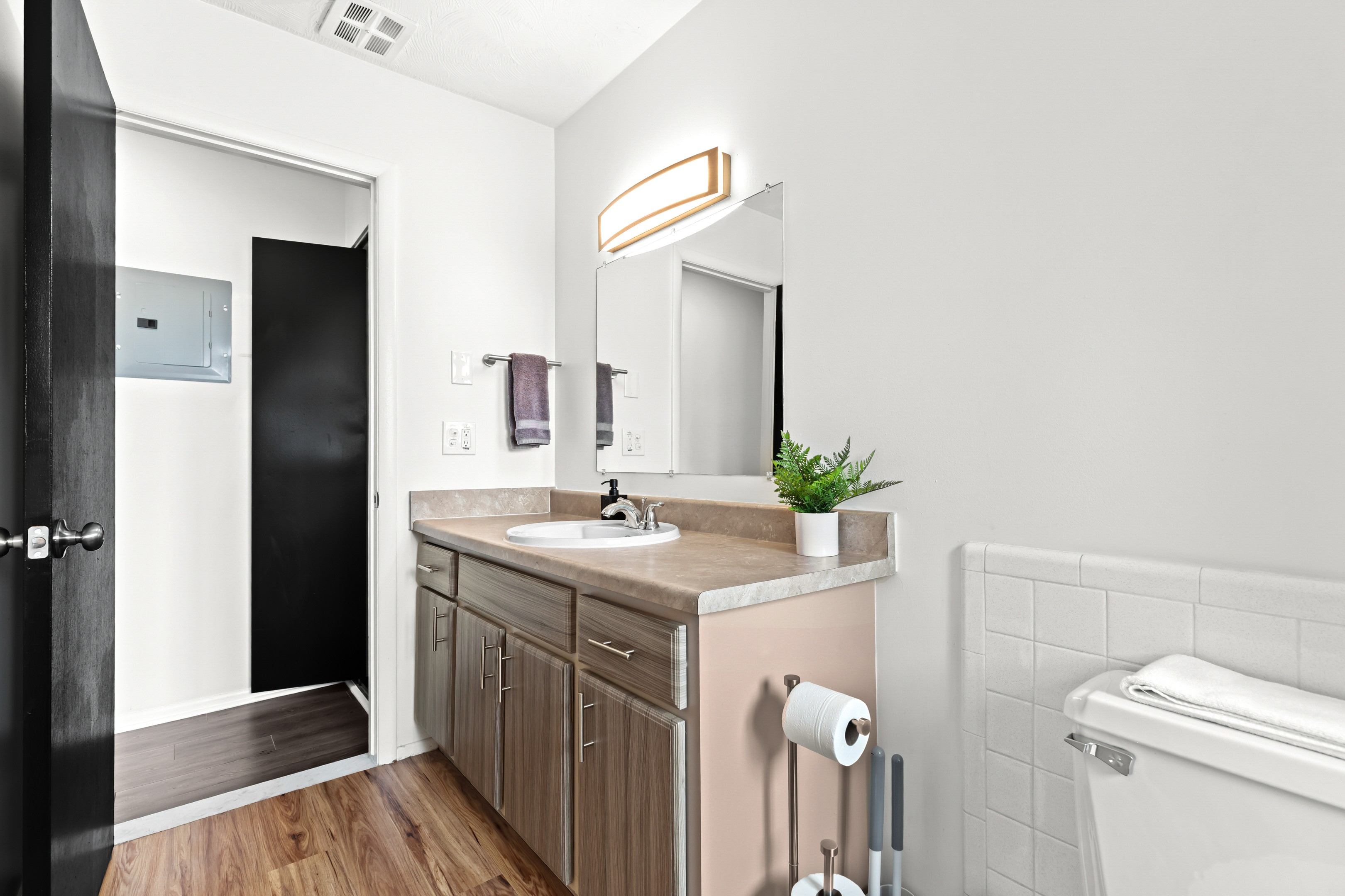 Enjoy a clean and modern bathroom complete with white tile accents, granite countertops, and a full-size tub and shower.